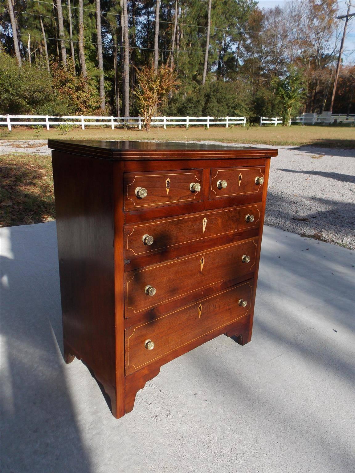 American Chippendale walnut and mahogany graduated five-drawer miniature chest of drawers with satinwood string inlay, inlaid escutcheons, original brass knobs and terminating on bracket feet. Secondary wood throughout is yellow pine, Late 18th