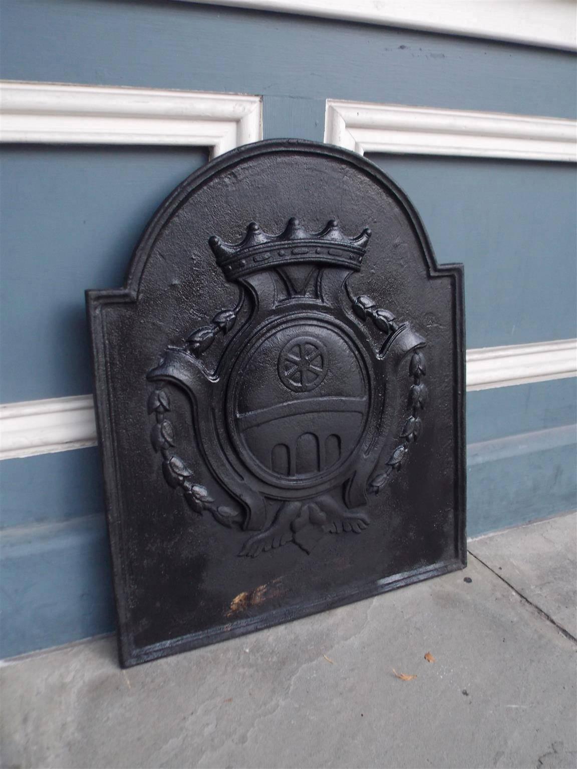 Plaque de cheminée en fonte anglaise en forme de pierre tombale avec un motif d'armoiries représentant une couronne, une fleur de cloche et un motif floral. Fin du 18e siècle.