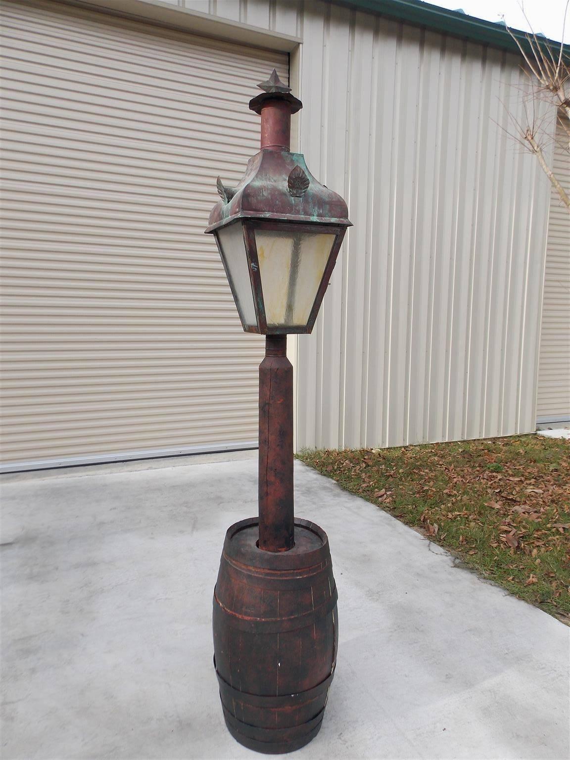 American gas copper street lantern with the original glass, floral motif, hinged door, mounted in a wooden wrought iron banded barrel, Early 19th century. 
Sturbridge, MA. Barrel dimensions are 16