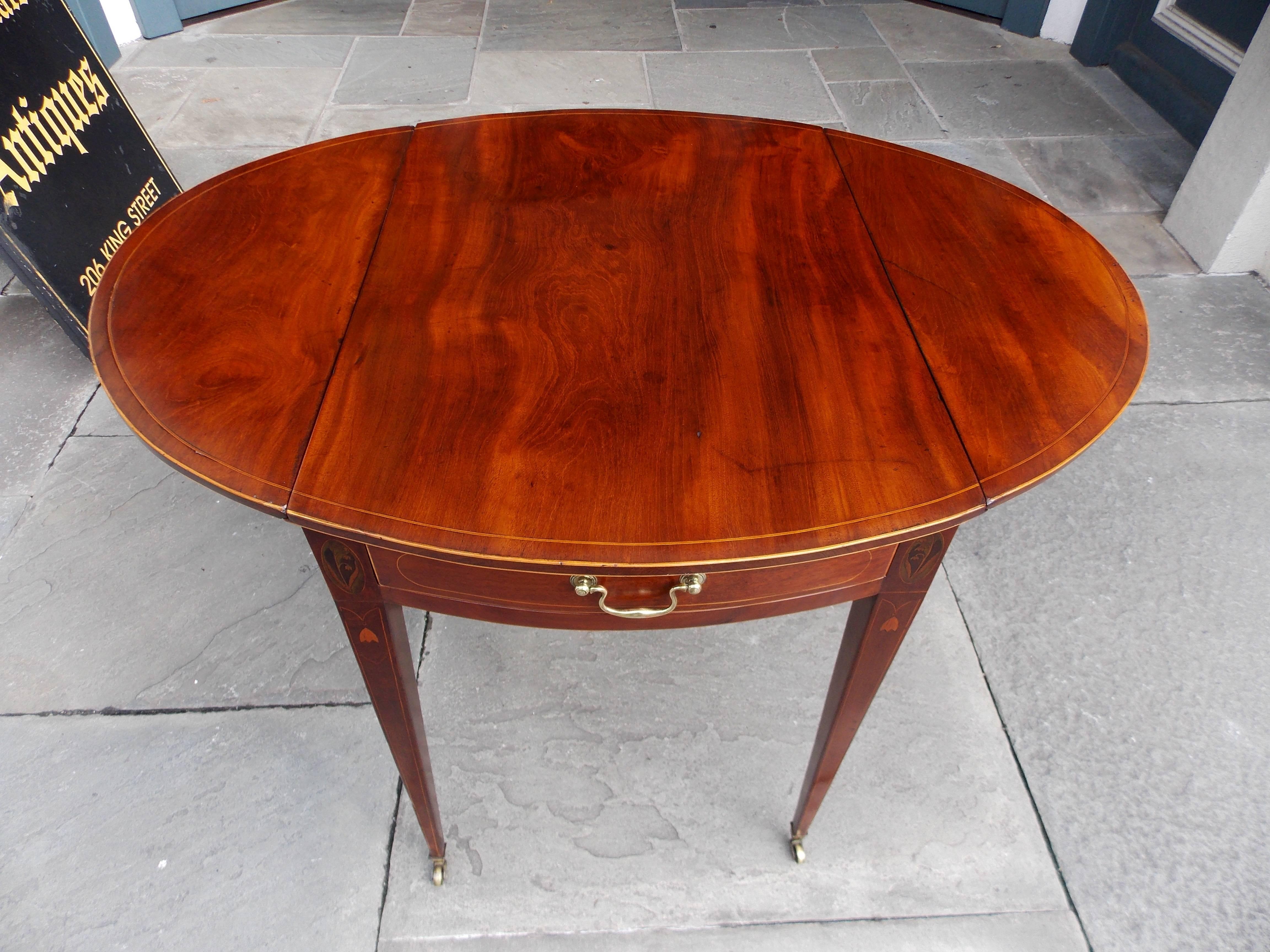 Charleston neoclassical mahogany one-drawer drop-leaf pembroke table with oval lilly of the valley inlay, bell flower and satinwood string inlay, and terminating on tapered legs with brass cup casters, Late 18th century. Table is 38.5