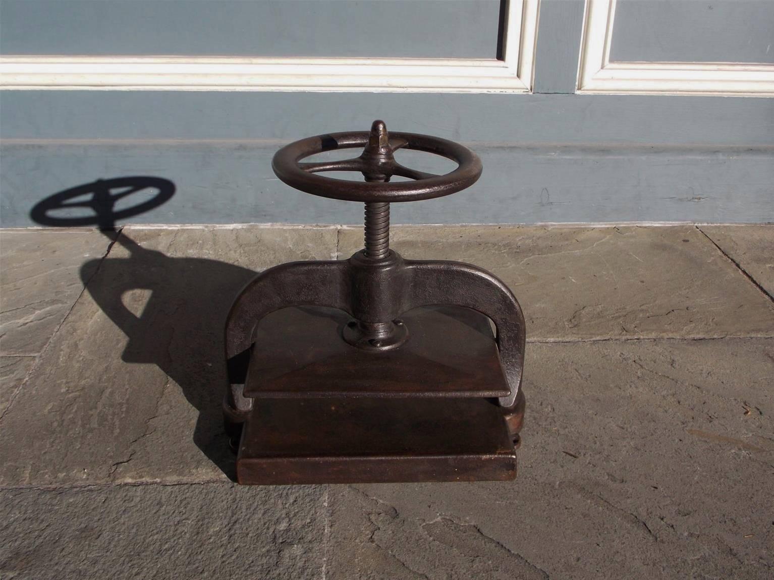 American cast iron copying press with a circular three spoke cork screw wheel, flanking scrolled support arms, pressure plate, and resting on the original rectangular base.  Early 19th Century