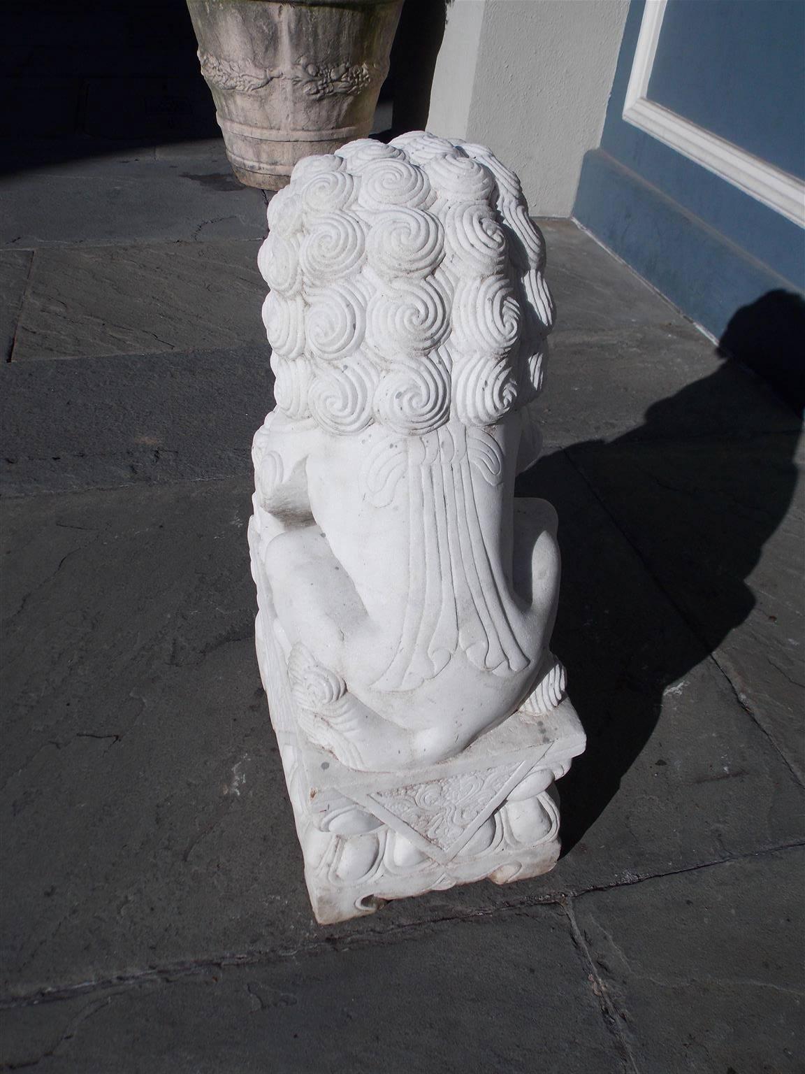 Hand-Carved Chinese Marble Foo Dog Resting on Squared Decorative Plinth, 20th Century For Sale