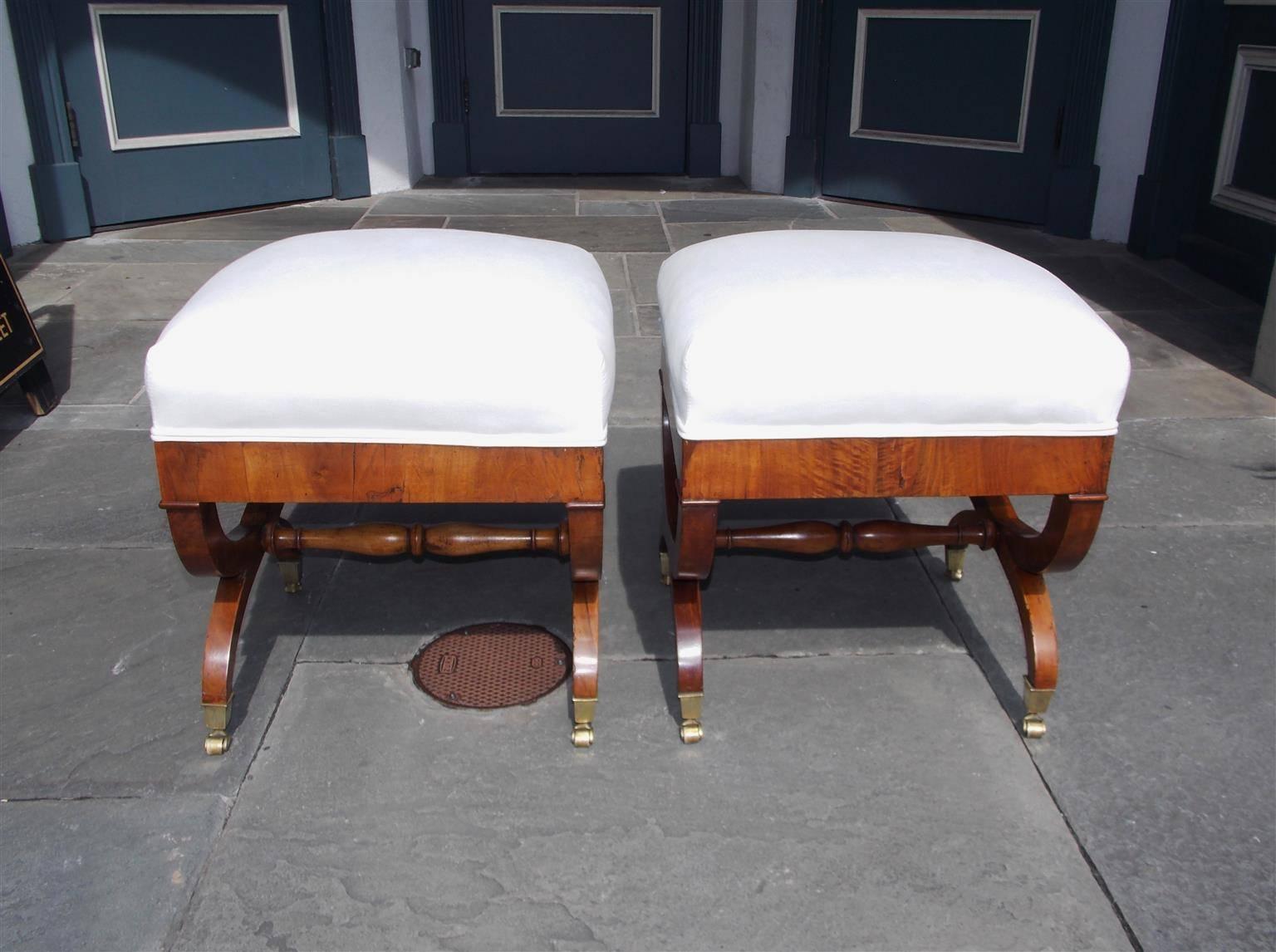 Pair of English walnut crule fire side benches with banded skirt, intertwined legs with connecting bulbous stretchers and terminating on original brass casters. Benches are upholstered in white muslin, Early 19th century.