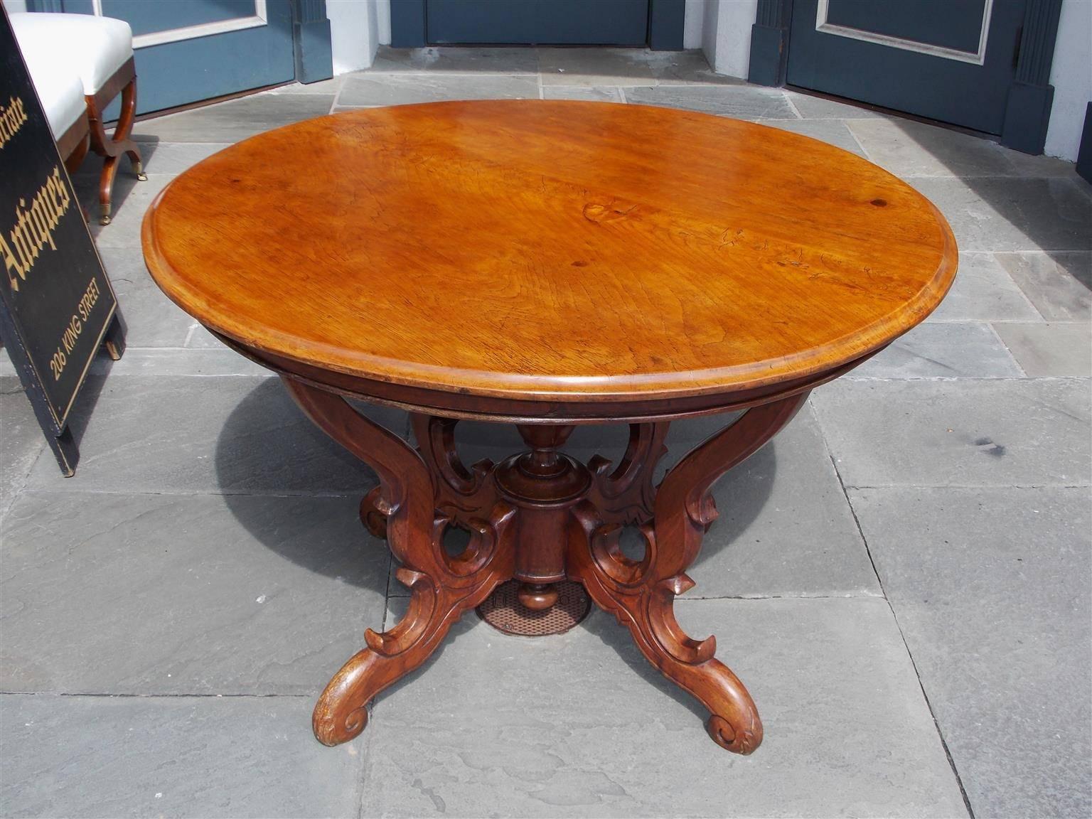 French walnut center table with one board top, carved banded skirt, centered urn, and resting on four acanthus scrolled legs. Early 19th century. Table skirt height is 26.5