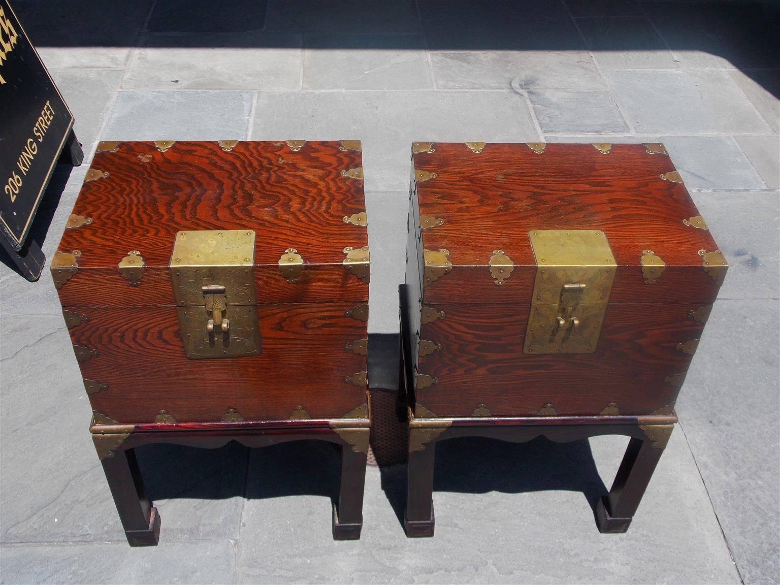Pair of Chinese document boxes on stand with original brass chased mounts, paper lined interior with Chinese writing, carved scalloped skirts , and resting on rectangular stands with squared legs and Marlboro feet. Boxes retain the original paper