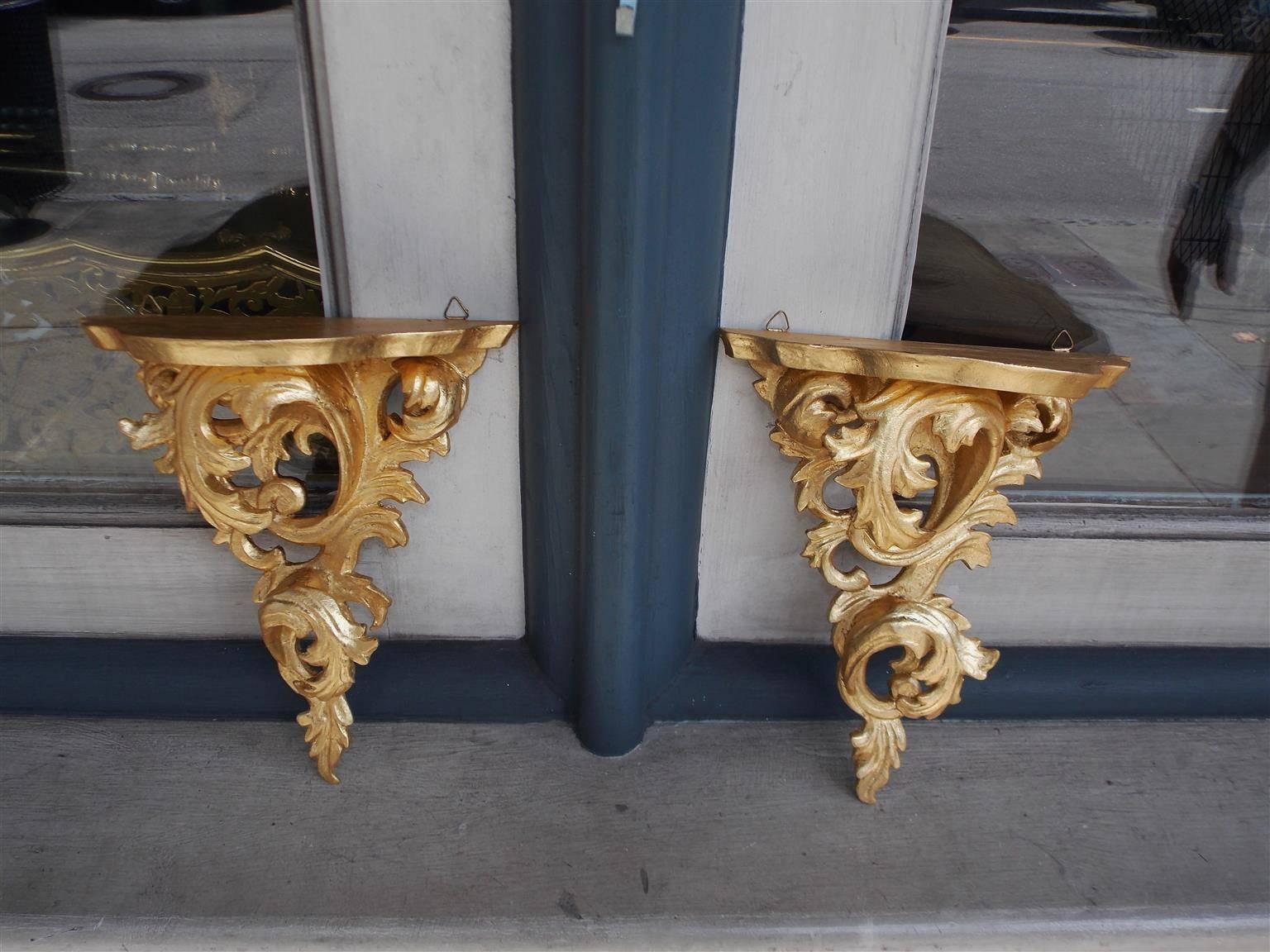 Pair of Italian gilt carved wood wall brackets with molded edge upper shelves and lower scrolled acanthus floral motif, Mid-19th Century.