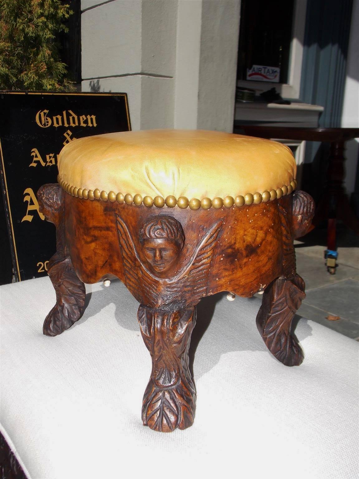 Italian burl walnut oval leather top foot stool with carved corner cherubs, scalloped skirt with ivory beading, brass tacks and resting on acanthus carved stylized lions paw feet . Mid-18th century.