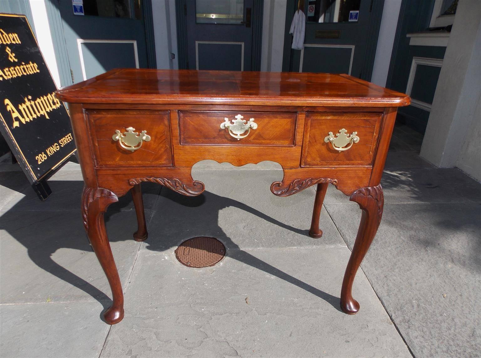 English Queen Anne burl walnut three-drawer low boy with inlaid feather banding, original brasses, acanthus carved serpentine skirt, and terminating on acanthus carved knees with the original pad feet. Mid-18th Century, lowboy is finished on back