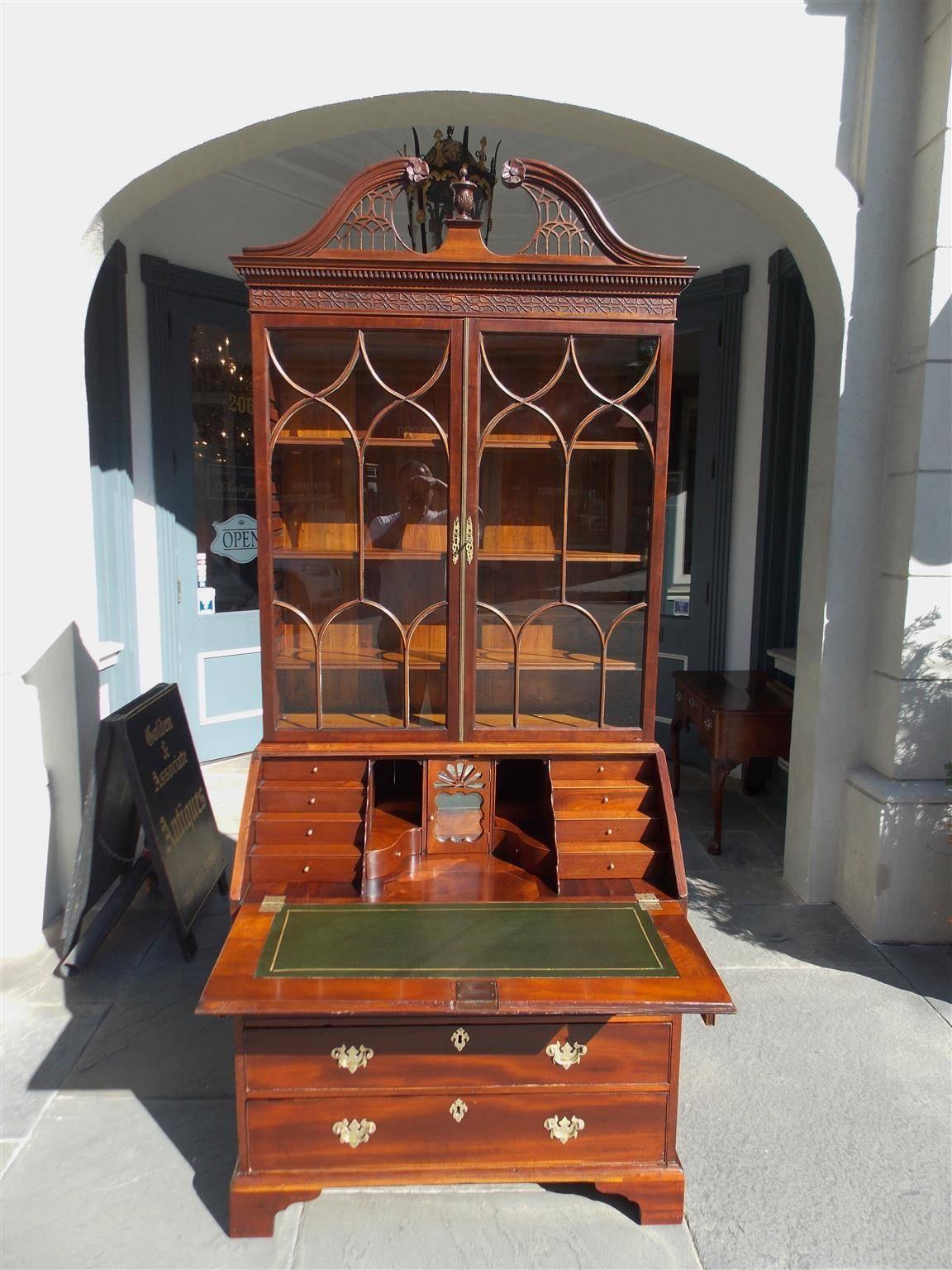 English Chippendale mahogany secretary bookcase with broken pediment cornice, intricately carved fret work and dental molding, original glass doors with adjustable shelving, step down fitted interior, graduated lower case drawers, and terminating on