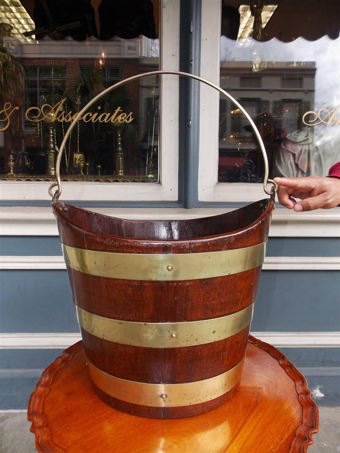 English navette form mahogany & riveted brass banded peat bucket with the original mounted brass handle. Early 19th century.