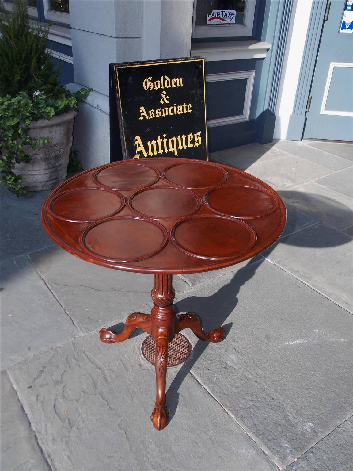 American Chippendale mahogany tilt-top desert table with seven circular carved molded dish segments, original locking mechanism with cleats, fluted spiral compressed urn pedestal, and resting on tripod legs, shell carved knees, and  ball & claw