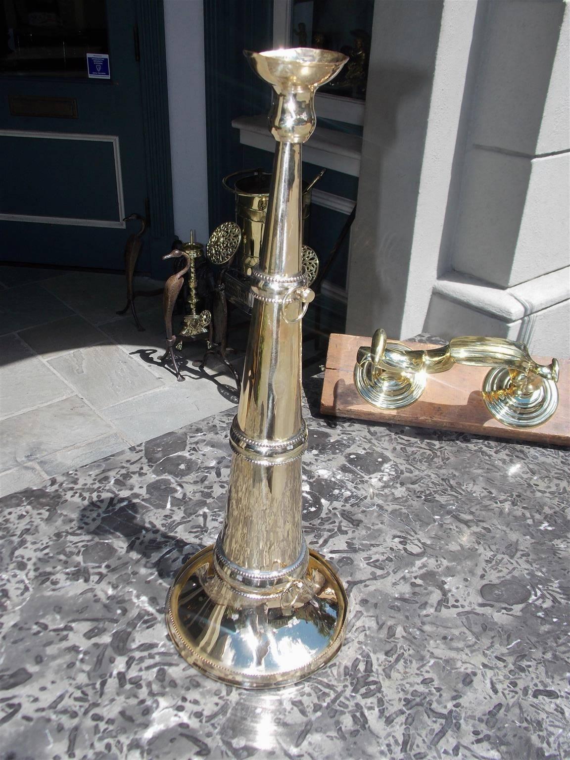 American hand held cast brass Yachtsman's spearing trumpet with bell shaped mouthpiece, coned-shaped column with fine detailed beaded bandings , attached rings for straps, and terminating on a molded edge opening, Mid-19th century. Trumpet was used