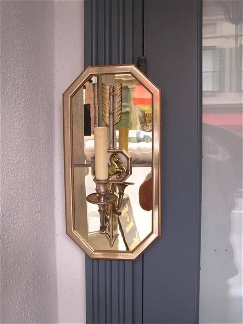 Pair of French one arm nickel silver and brass wall sconces with the original octagon shaped mirrored backs and a centered decorative seahorse and arrow motif medallion. Pair were originally candle powered and have been electrified, Late 19th