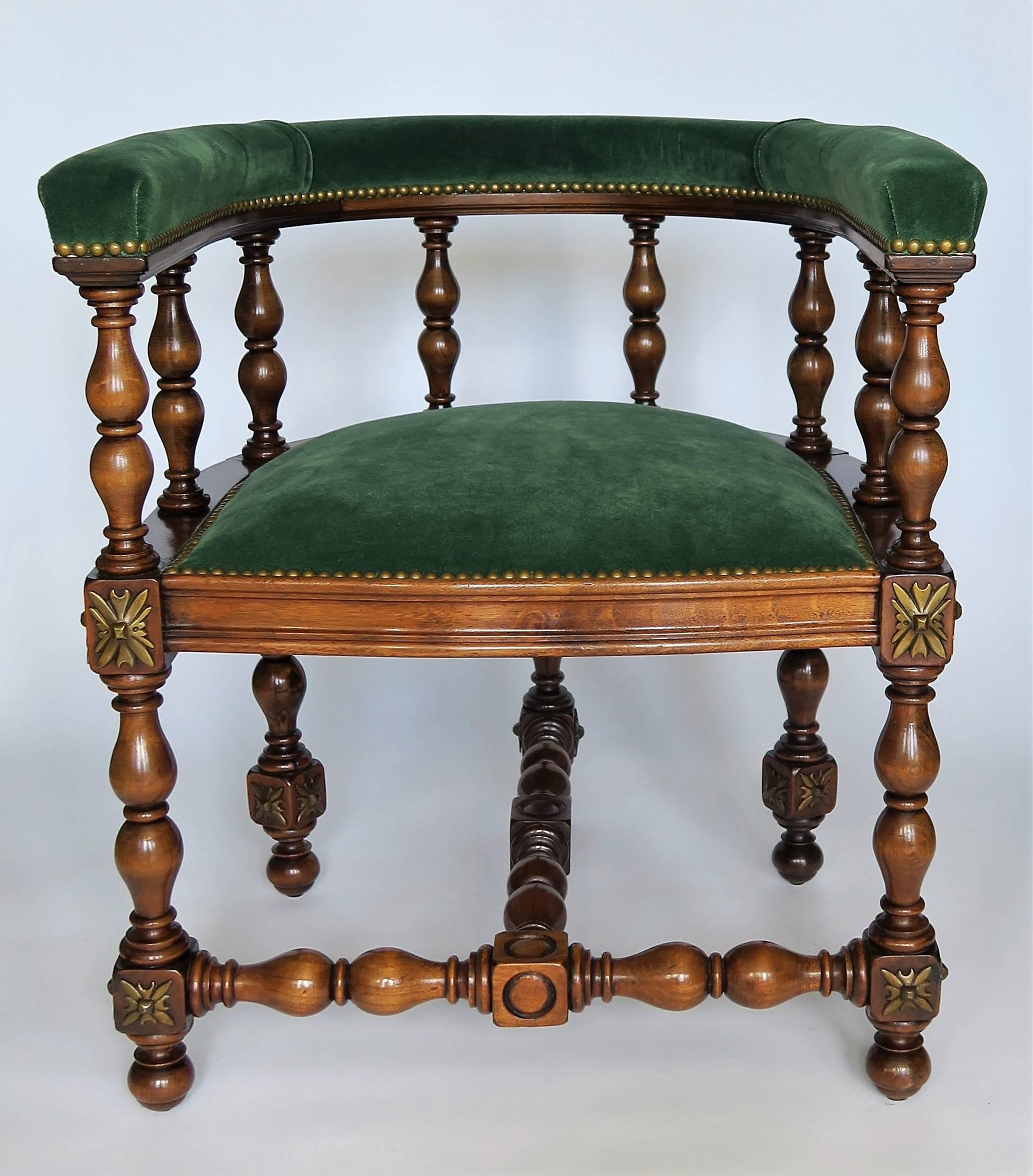 Decadent and refined, this pair of elegant barrel back Jacobean styled armchairs or library chairs have detailed hand-turned legs and back. The oakwood is rich with gorgeous patina, brass escutcheons medallions on each leg corner complete the look.