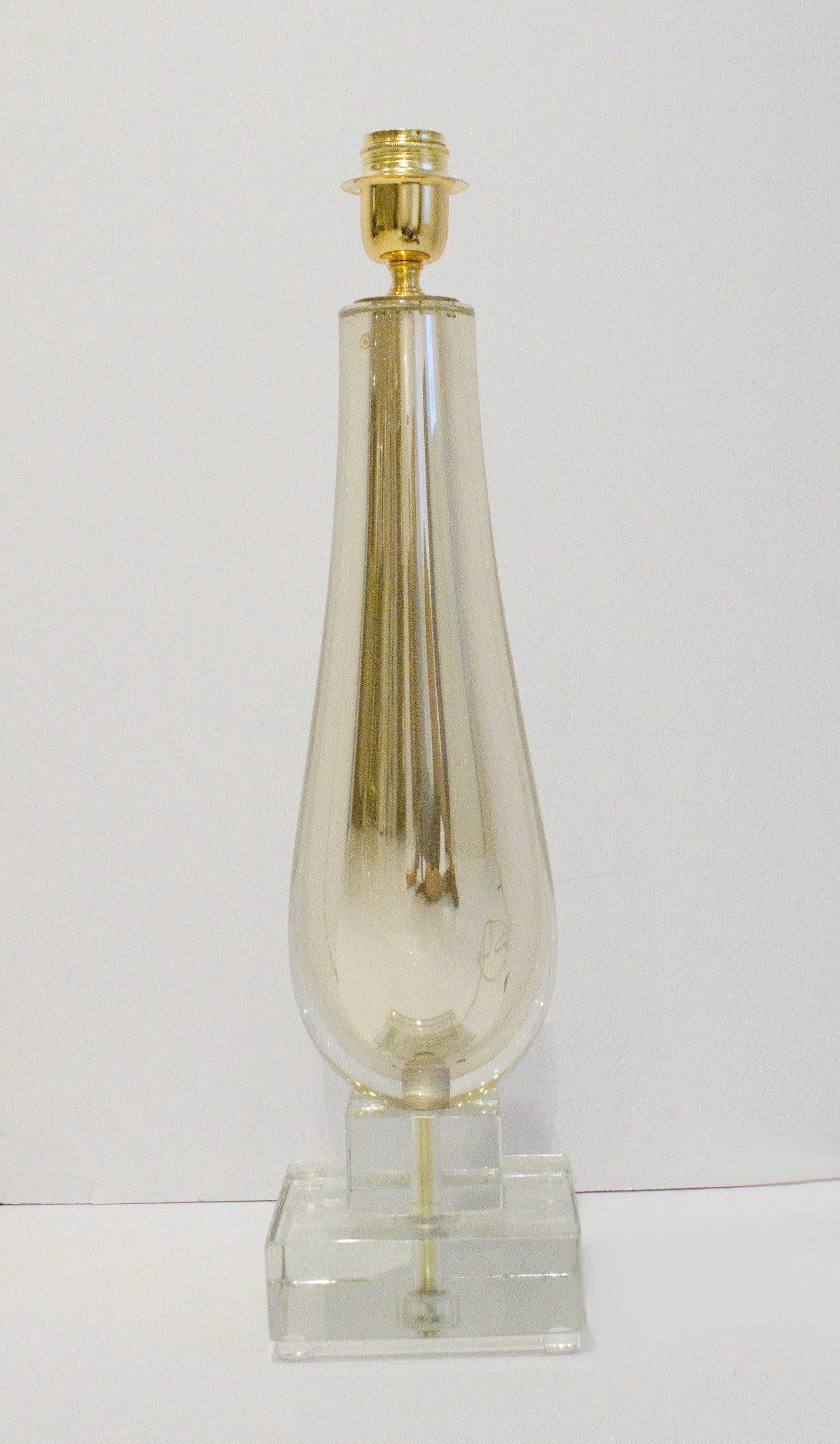 Cette lampe en verre clair et or de Murano est composée de verre clair soufflé à la main et superposé à du verre au mercure doré scintillant pour créer un effet de miroir. La base ornée de bijoux repose sur deux solides blocs de verre clair de