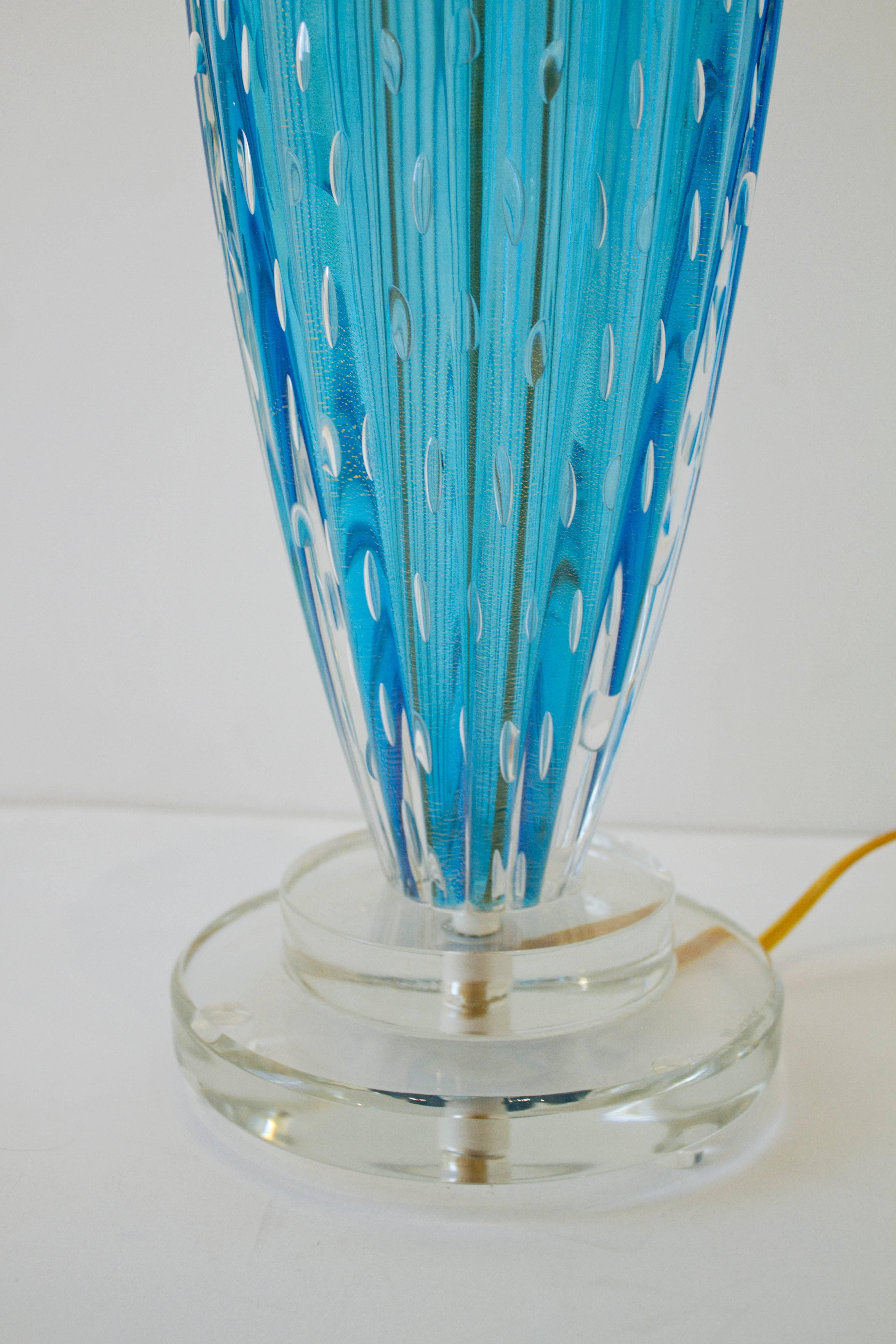 A stunning pair of hand blown aquamarine blue or blue topaz colored Murano glass lamps. These clear blue bases were hand blown using the 
