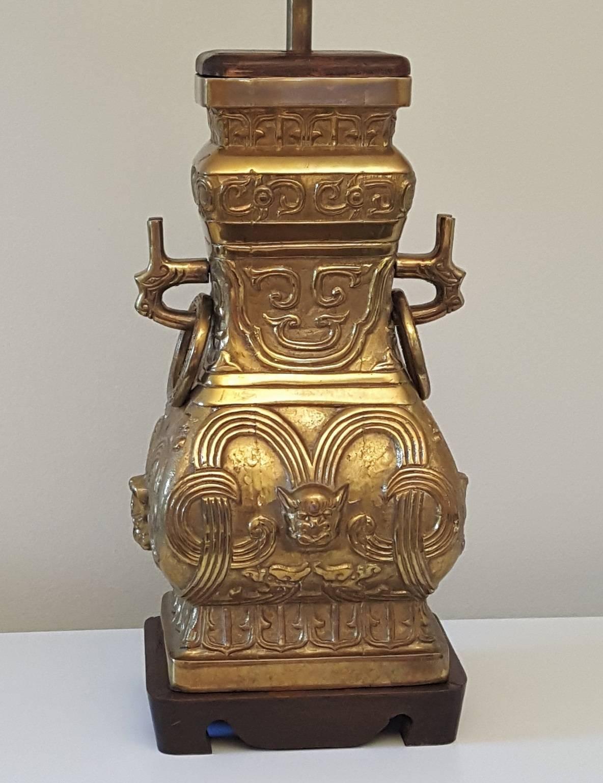 Incredible pair of massive Chinese style archaic bronze or brass urn vessels mounted as table lamps. Gorgeous antiqued patina completes the effect of these pieces. Each lamp weighs over 20 pounds and is made of solid bronze or brass except the wood