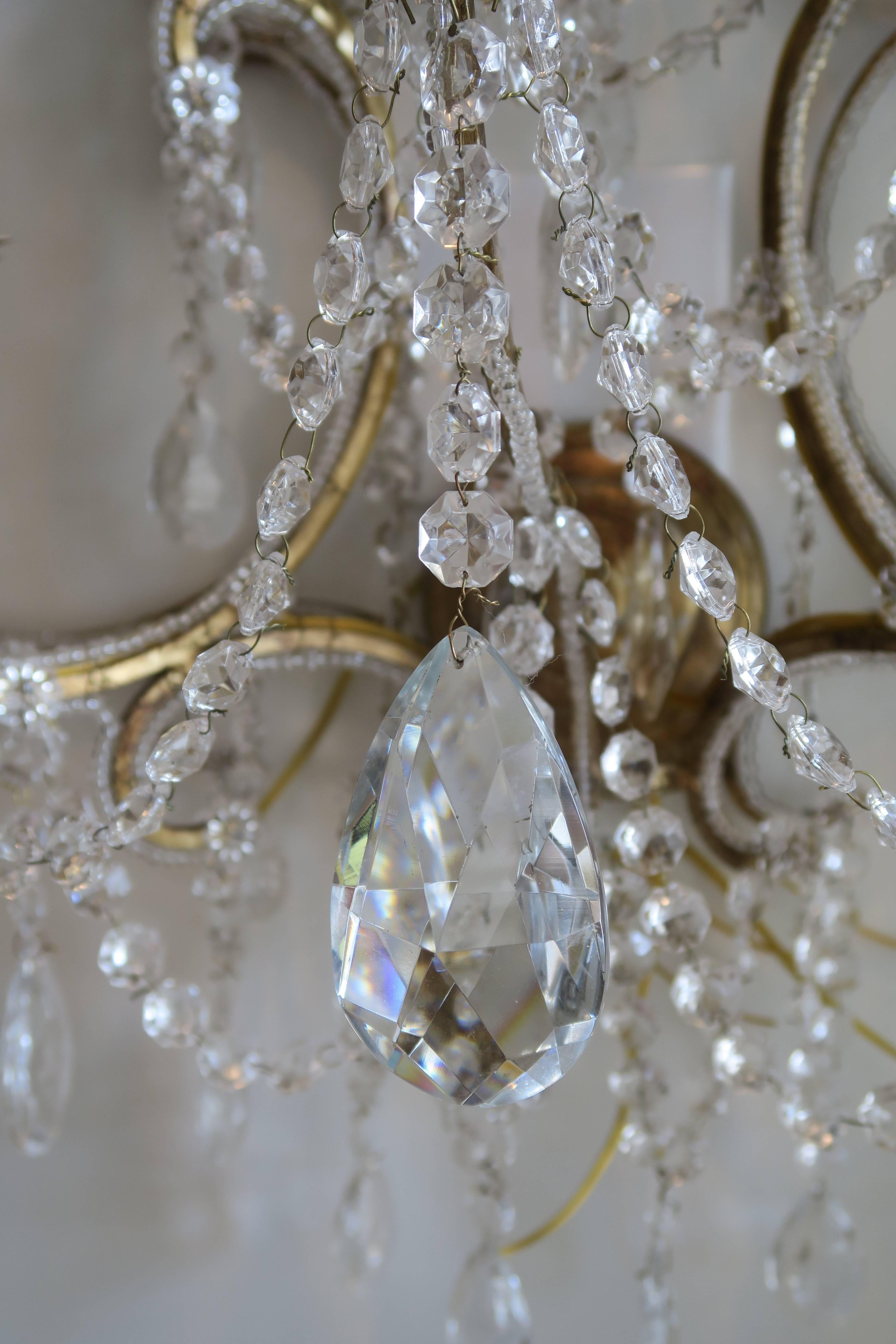 This monumental large pair of beaded Murano glass crystal scones are handcrafted in Italy by a second generation chandelier maker. Large Murano glass crystals are meticulously hand knotted and tied and crystal beadings are wrapped around each of the