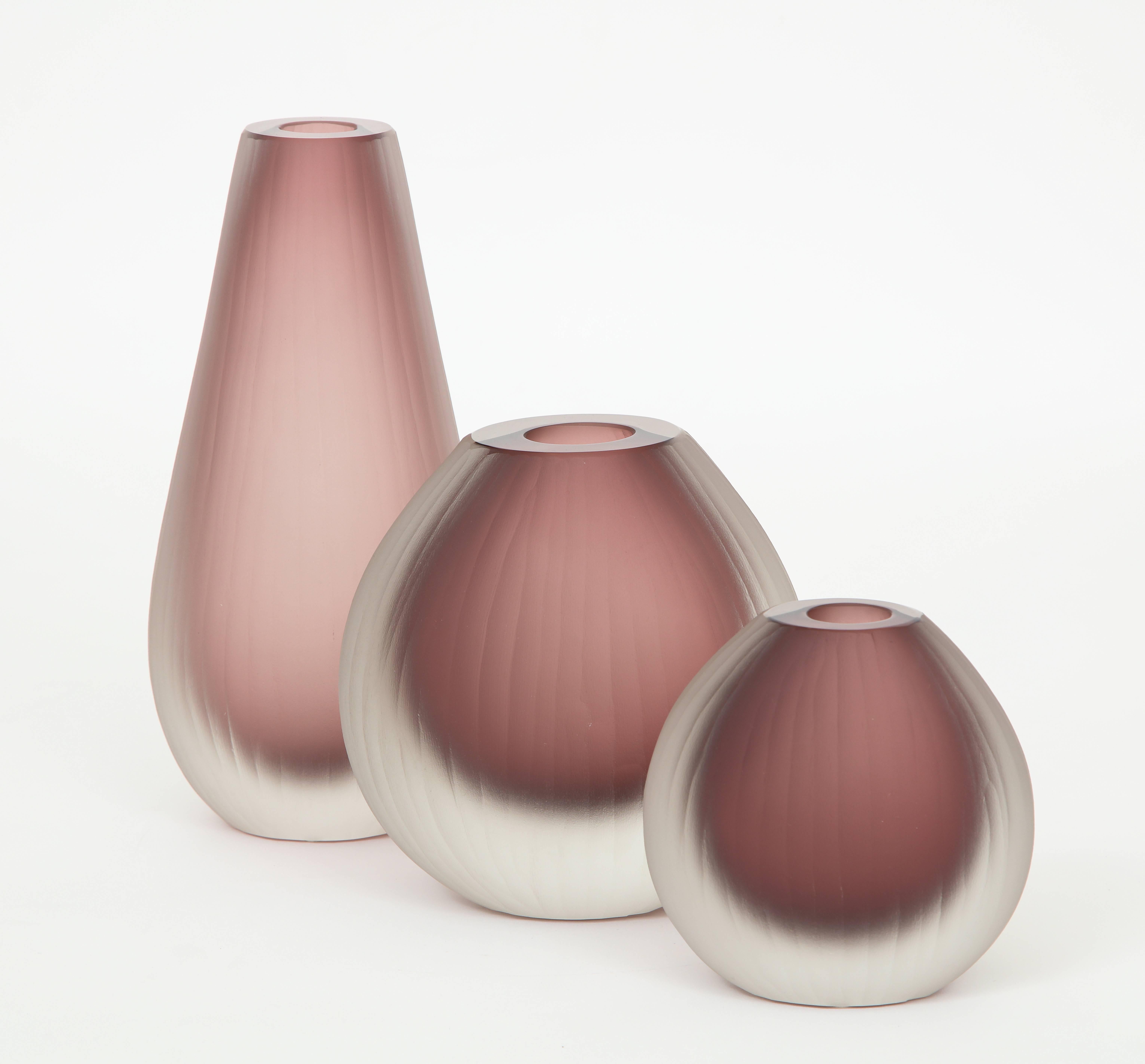 Set of three handblown oval Murano glass vases. Glass is softly ridged and frosted to give it that "iced" look. The color is absolutely stunning in Amethyst / Rose depending on how you look at them. Signed by the Murano glass master