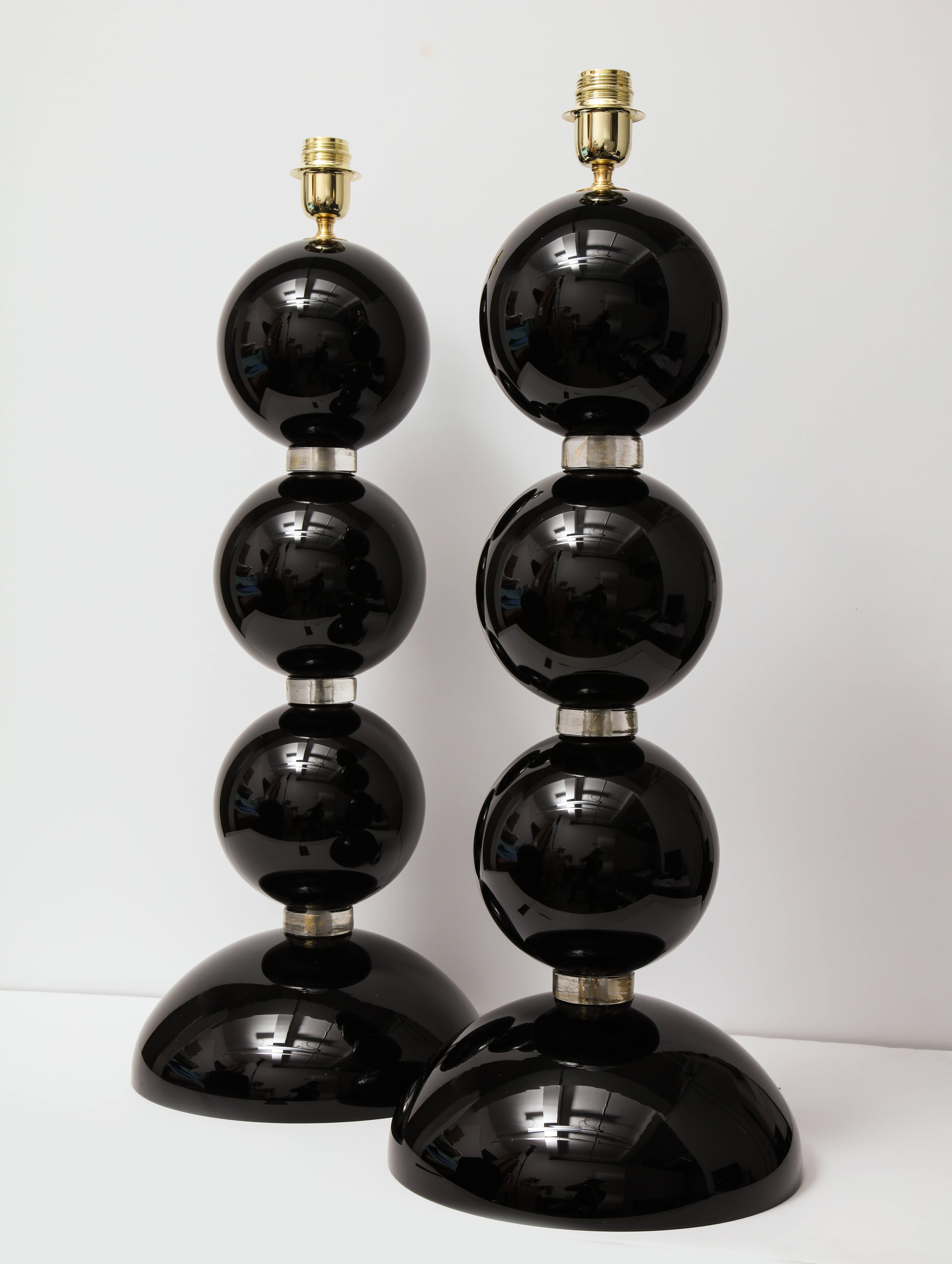 Pair of impressively large Italian hand blown Murano black and gold glass sphere lamps. Solid black Murano glass spheres are separated by clear glass rings infused with 23-karat gold flecks, giving them a shimmering jeweled look. Signed by the glass