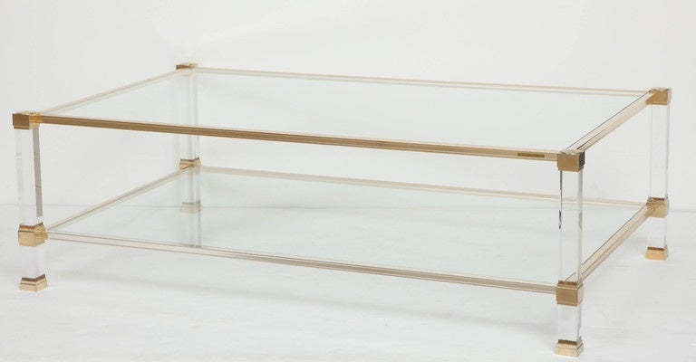 Designed by Pierre Vandel in Paris in the 1970s.
This elegant coffee table is made with clear Lucite legs 
and gilded brass.