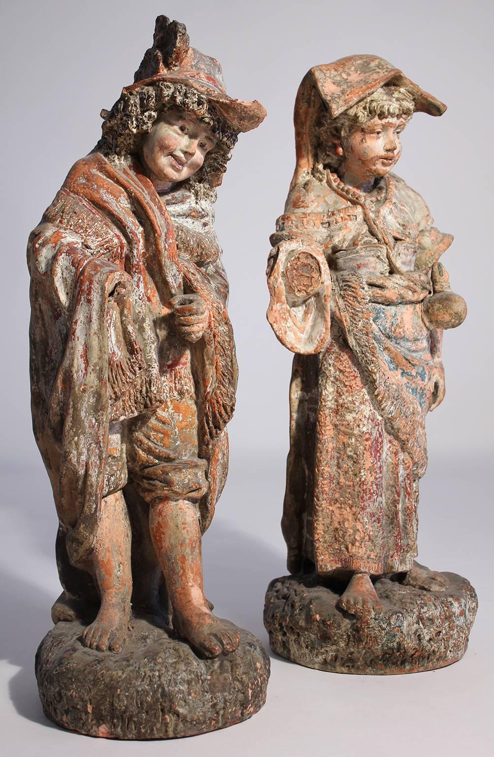 Wonderful pair of antique painted terracotta garden sculptures or figures with a perfectly aged and weathered patina. Each piece standing just over 2 feet tall.