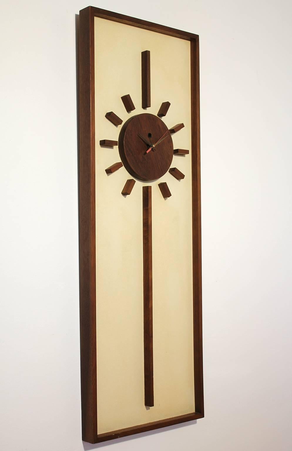 1960s modernist California Design walnut wall clock from Peter Pepper Products. Originally a wind up clock, this has been updated with battery operated quartz movement. Works perfectly and keeps time.