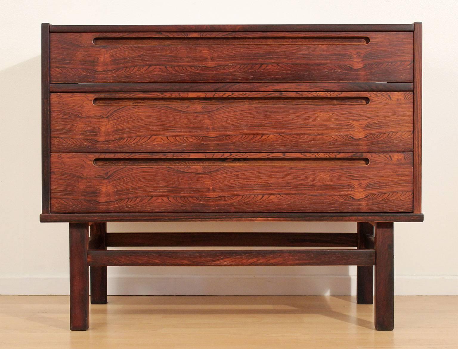 Beautiful Danish rosewood vanity dresser by Nils Jonsson for HJN Mobler, Denmark, circa 1960. The three-drawer dresser features a vanity top with mirror. This piece slides out to be used as a vanity. Beautiful grain in the rosewood. Restored to the