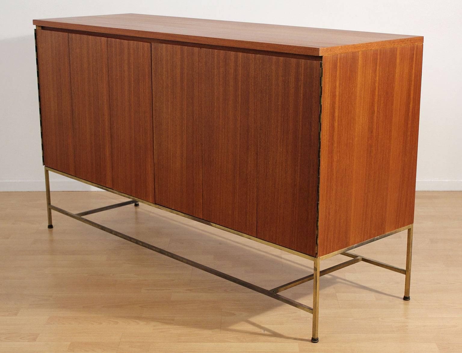 Excellent Paul McCobb designed Credenza for Calvin Furniture, circa 1950s. Iconic style and design. Base is brass with a wonderful patina. Mahogany wood has been refinished and hand oiled to bring out the beauty of the wood. This credenza is a