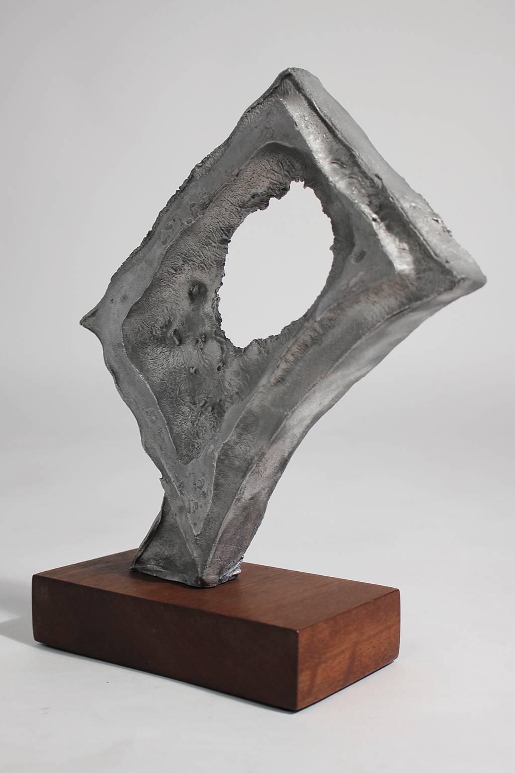 Modernist abstract free-form aluminium on walnut base sculpture. This vintage piece is unsigned but the quality of the sculpture is great. I am sure this sculpture was done by a well know artist. Displays well and would be a great addition to any