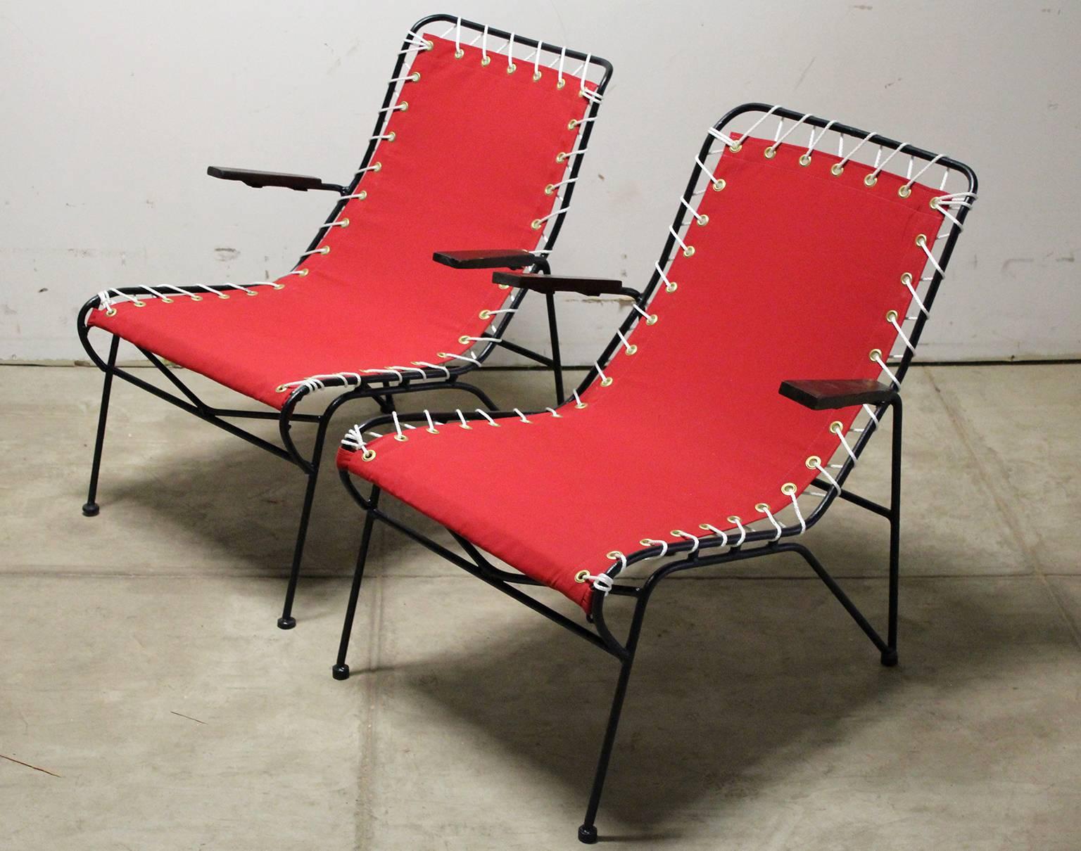 Beautiful pair of restored Pipsan Saarinen-Swanson outdoor patio arm chairs for Ficks Reed, circa 1949. The have wrought iron frames with redwood arms. The canvas has been redone and the frames are freshly painted. All the rope and grommets have
