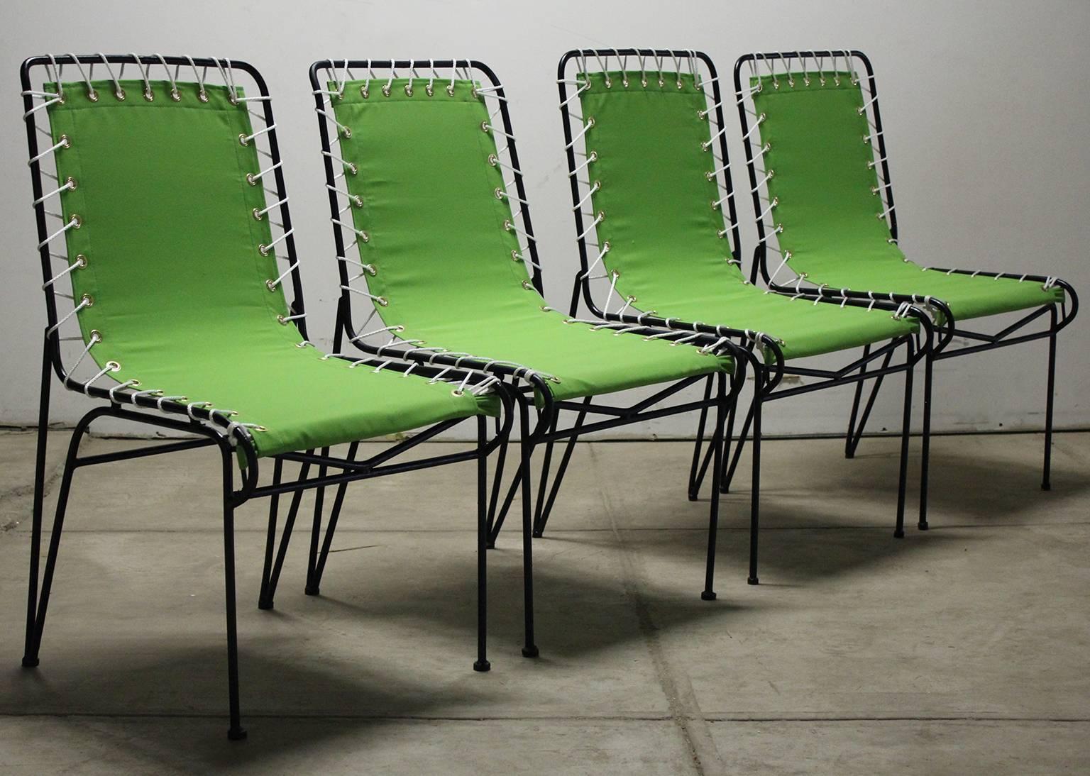 Beautiful set of four restored Pipsan Saarinen-Swanson outdoor patio sitting chairs for Ficks Reed, circa 1949. The have wrought iron frames with canvas seats. The canvas has been redone and the frames are freshly painted. All the rope and grommets