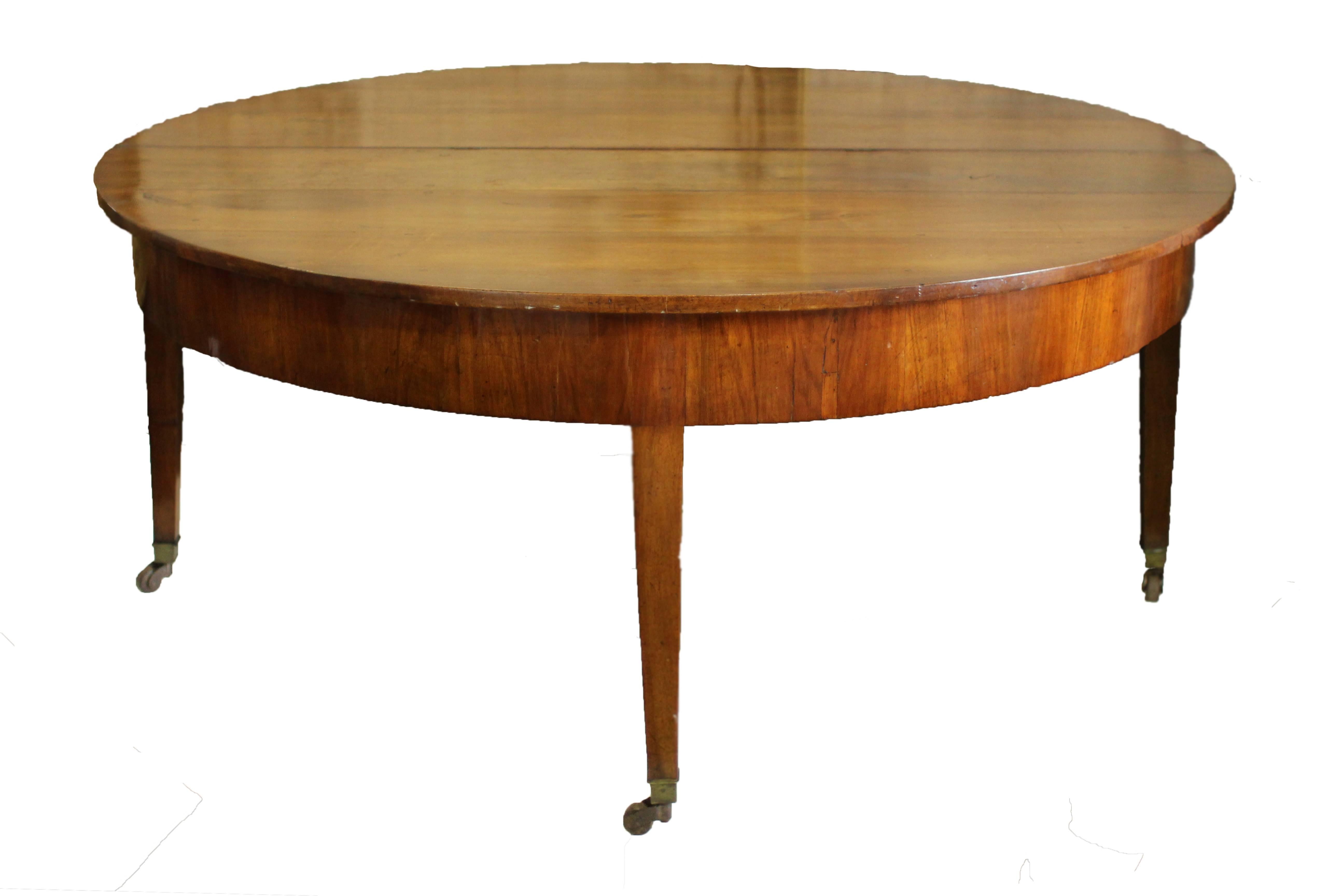 Extraordinary round table with drop-leaf fold to make a demilune. Beautiful walnut with four legs that extend to rolling casters.

Fully extended measurements are 66.5