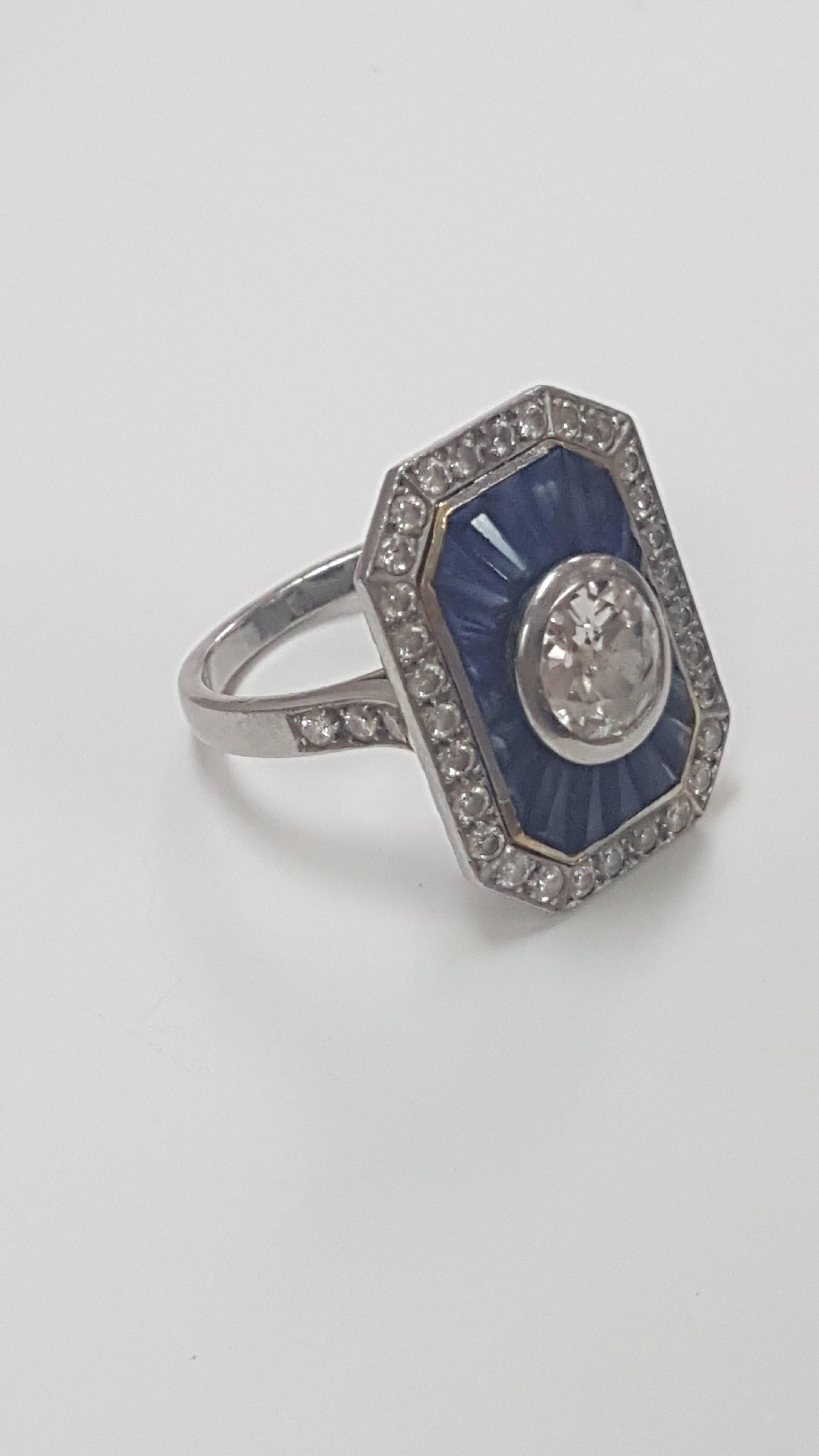 Vintage synthetic sapphire and diamond ring. 1ct mine cut center diamond surrounded by synthetic sapphires and small diamonds. Heart shaped details on setting.