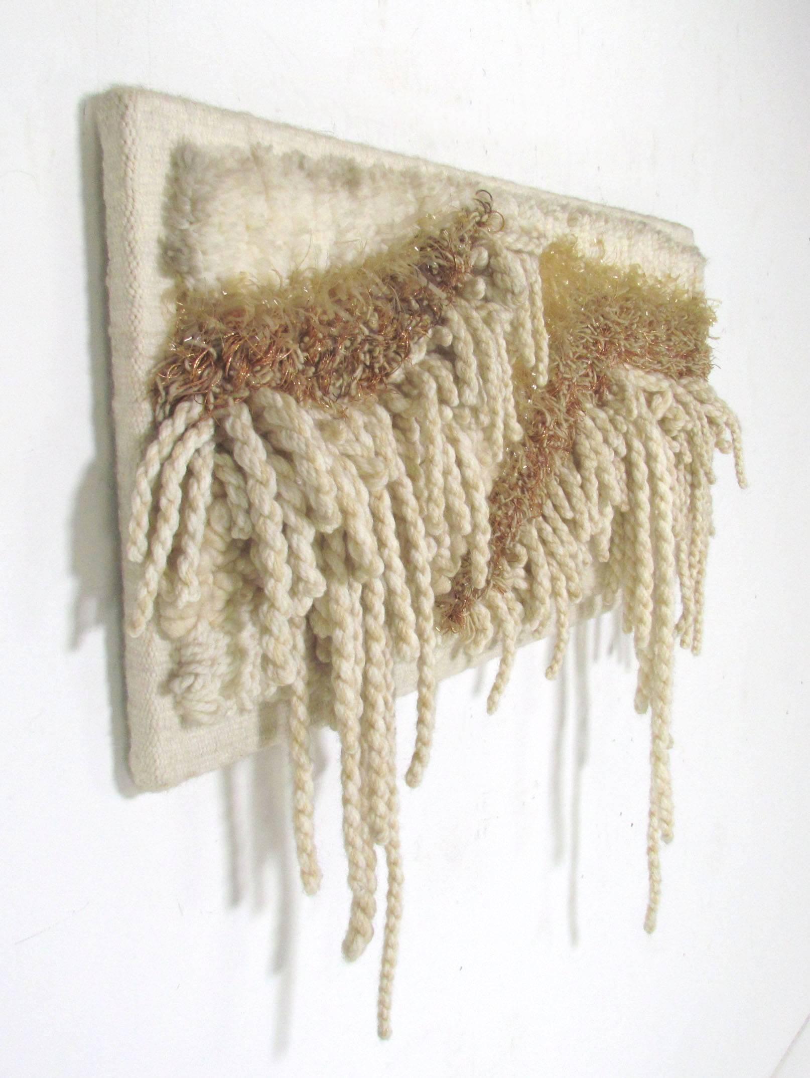 An abstract fiber art construction woven of wool, cotton, copper wire and cellophane, signed by the artist, circa 1970s.