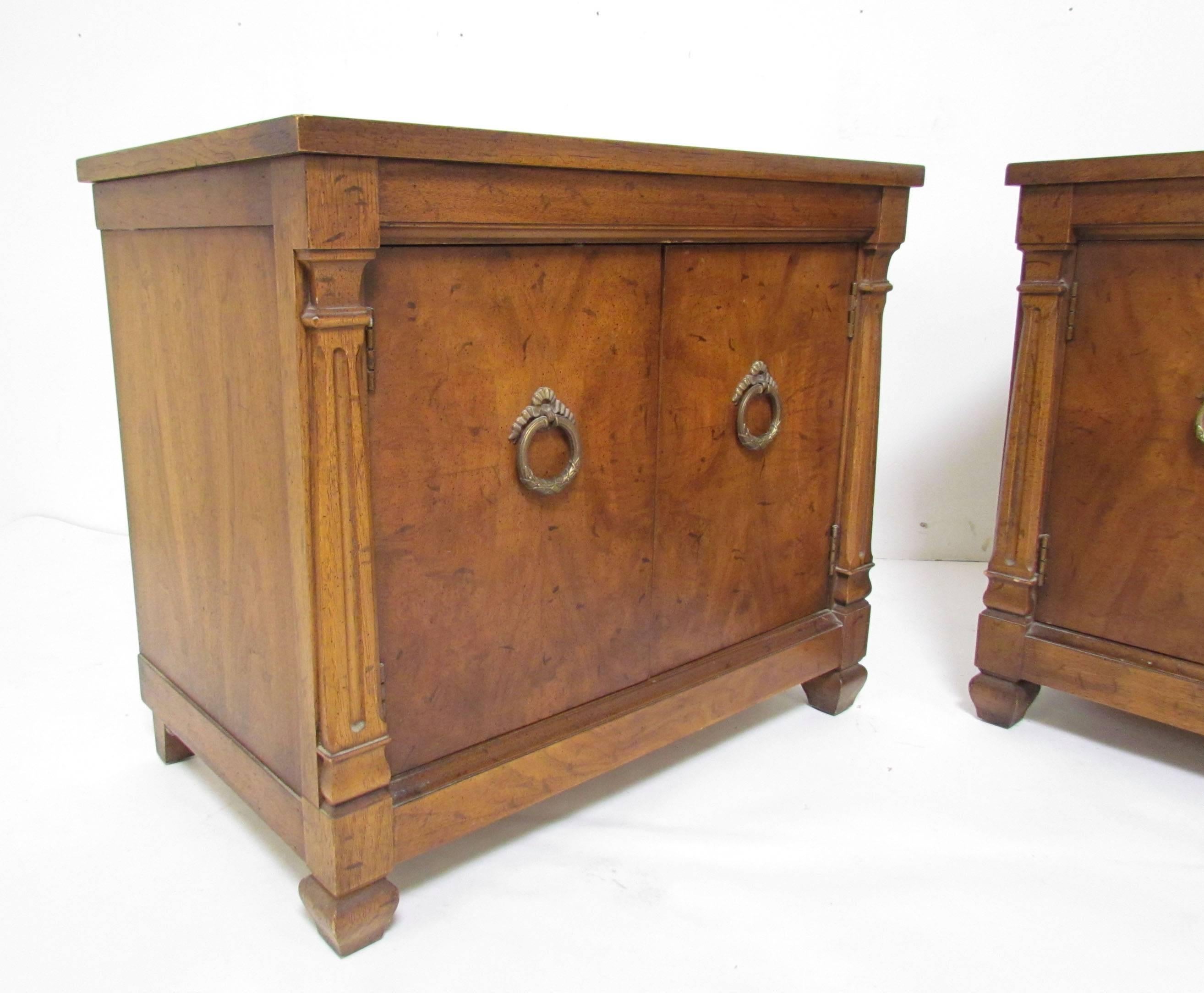 Pair of Mid-Century nightstands in walnut hardware in the Hollywood Regency style by Heritage Furniture.