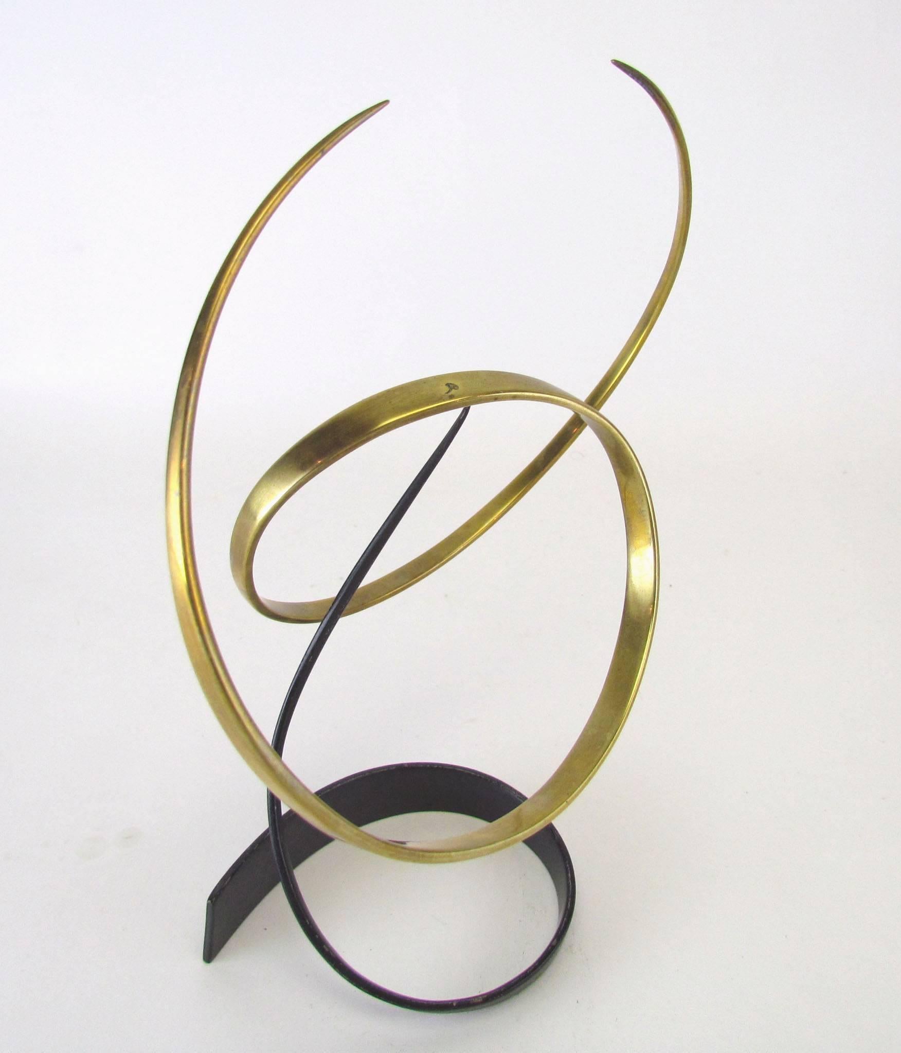 Abstract desk top sculpture, ribbon form brass element balanced upon a bronze pivot. Two-piece Kinetic stabile, with excellent balance. Signed with artist's cipher.