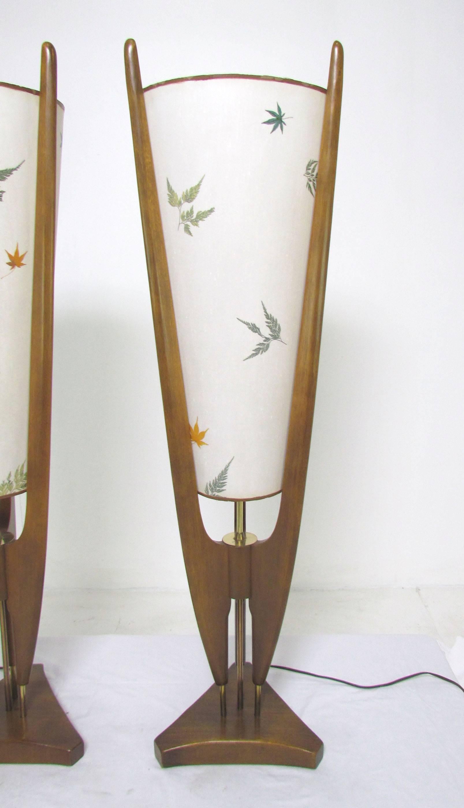 Pair of Mid-Century table lamps with printed parchment shades by Modeline, walnut tri-arm frame with brass accents.
