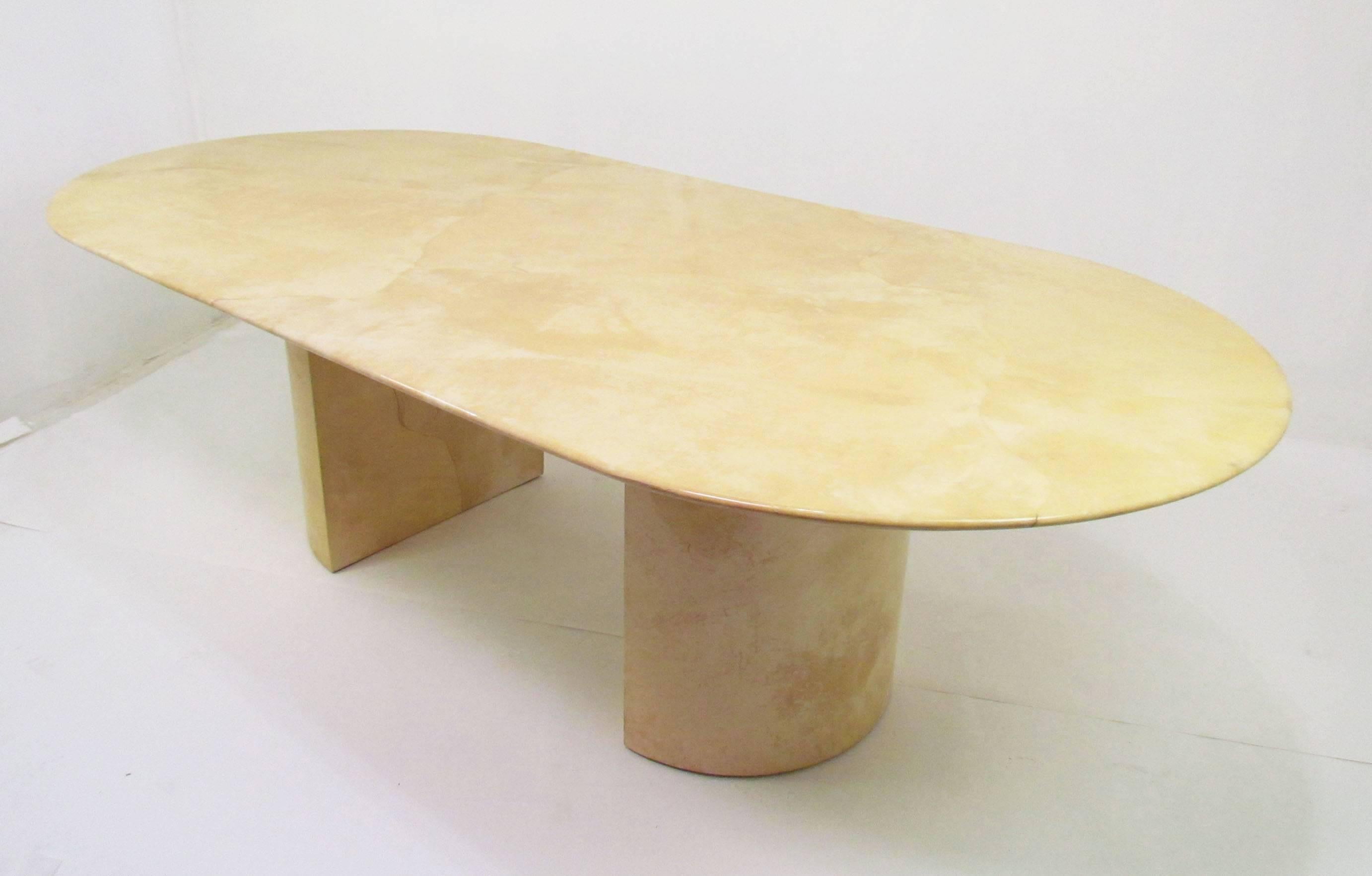 Large oval racetrack dining table supported by two demilune pedestals, all clad in genuine lacquered goatskin. Although no longer retains a label, many examples of this knife edged table exist that are signed Karl Springer. Each pedestal base is