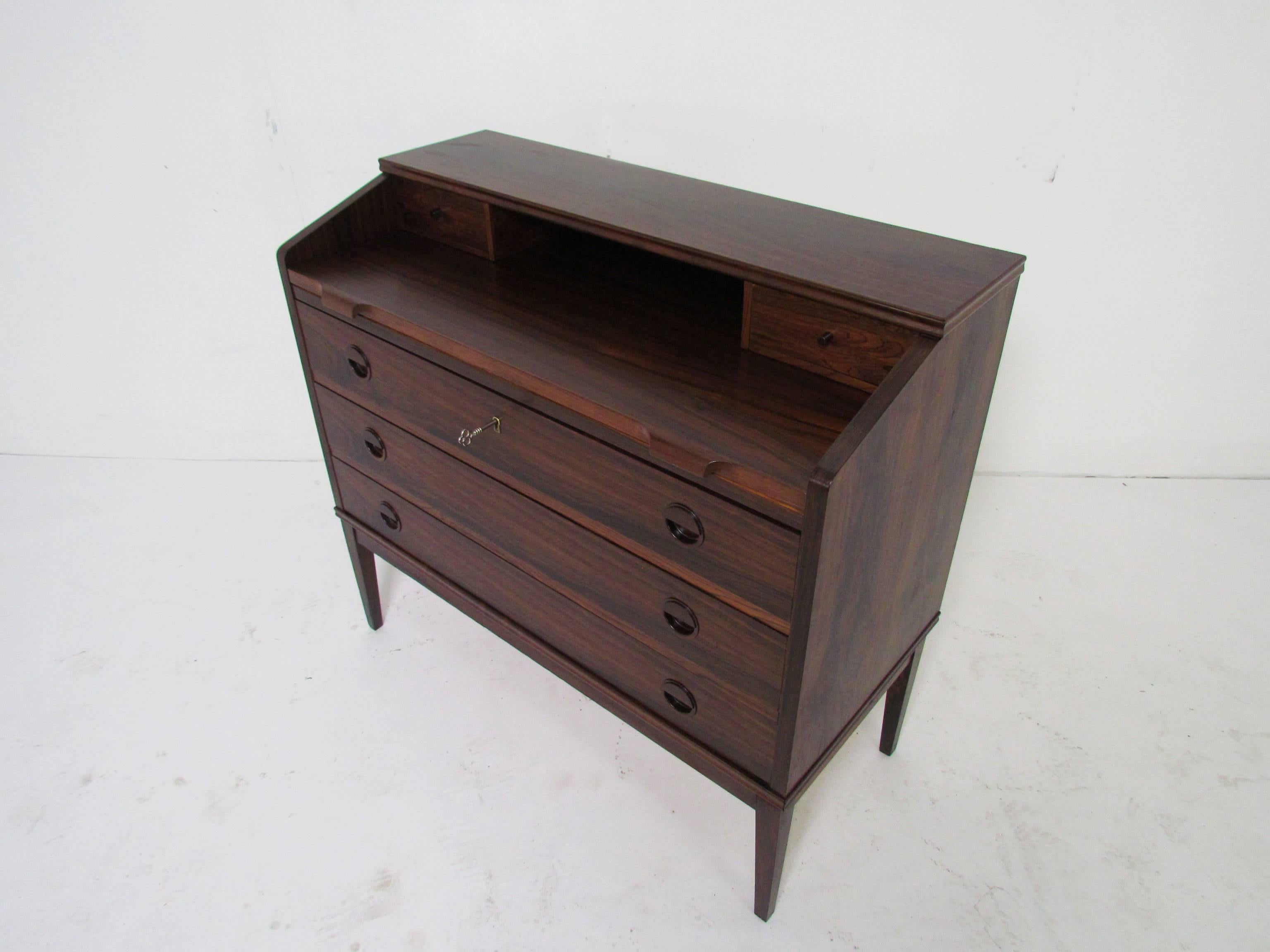 Rosewood secretary desk with pull-out desk top, three large lower drawers (one with key) and two upper small stationery drawers. Made by Riis Antonsen, Denmark.

Height to desk surface is 29