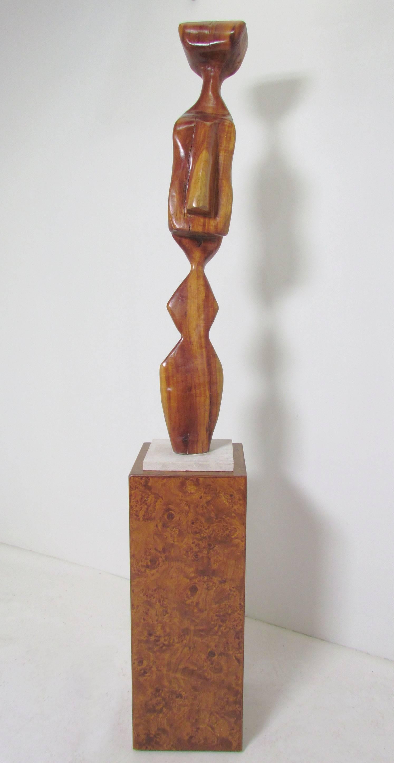 Large Abstract totemic wood carving signed "A. Janes, 1974". This soaring modernist work is offered with a befitting Italian burlwood pedestal.

Sculpture measures 41.5" tall, with a marble base 8.5" square (Sculpture