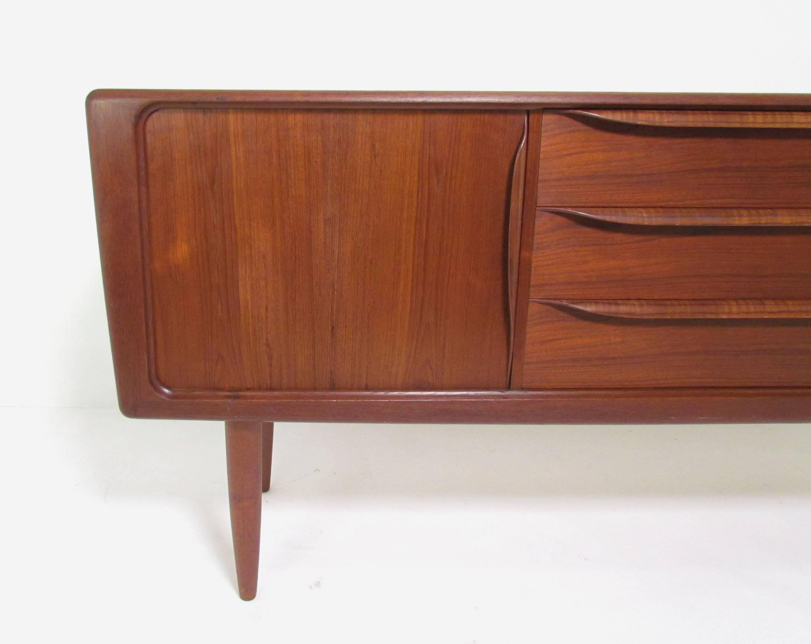 Exceptional Danish teak sideboard with tambour doors and middle section of storage drawers, designed for the Copenagen fine furniture store Hos Wulff, circa 1960s, in the manner of Bernhard Pederson & Son designs for the shop. Contoured