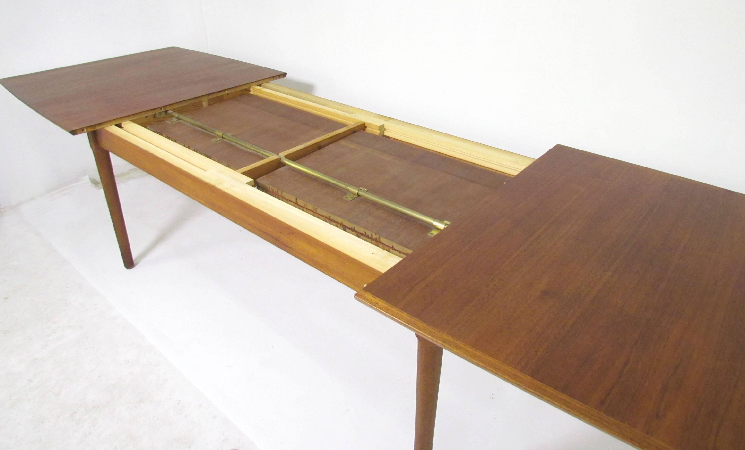Danish teak dining table with two internally stored butterfly leaves, expands from 77.5” long when leaves are not in use to 130” (nearly eleven feet) when both leaves are used. Made by Falster, Denmark, circa 1960s. Perhaps the largest Danish made