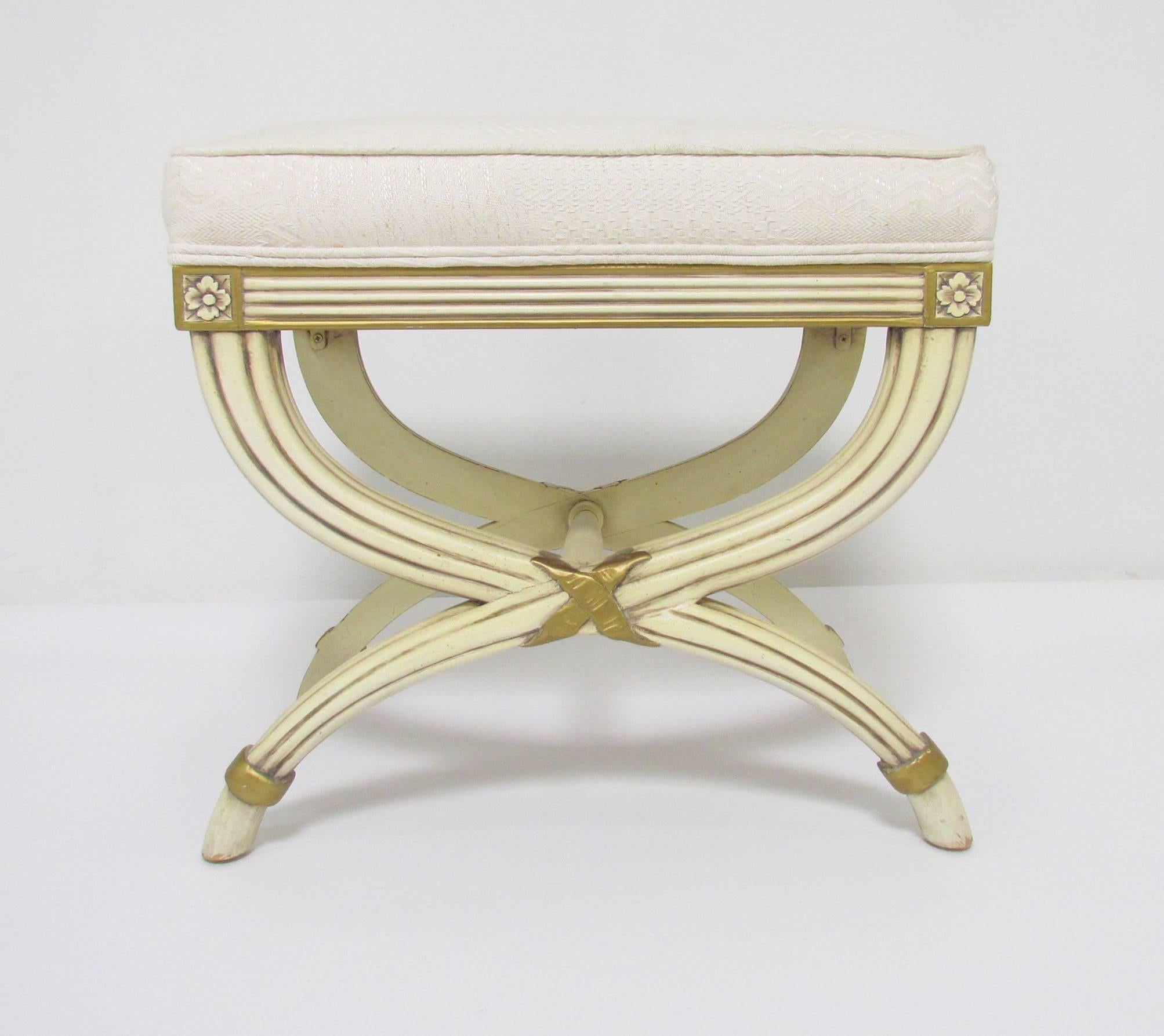 Pair of upholstered stools with neoclassical design elements, X-form legs carved florets and gilded accents, by Karges Furniture, circa 1950s.