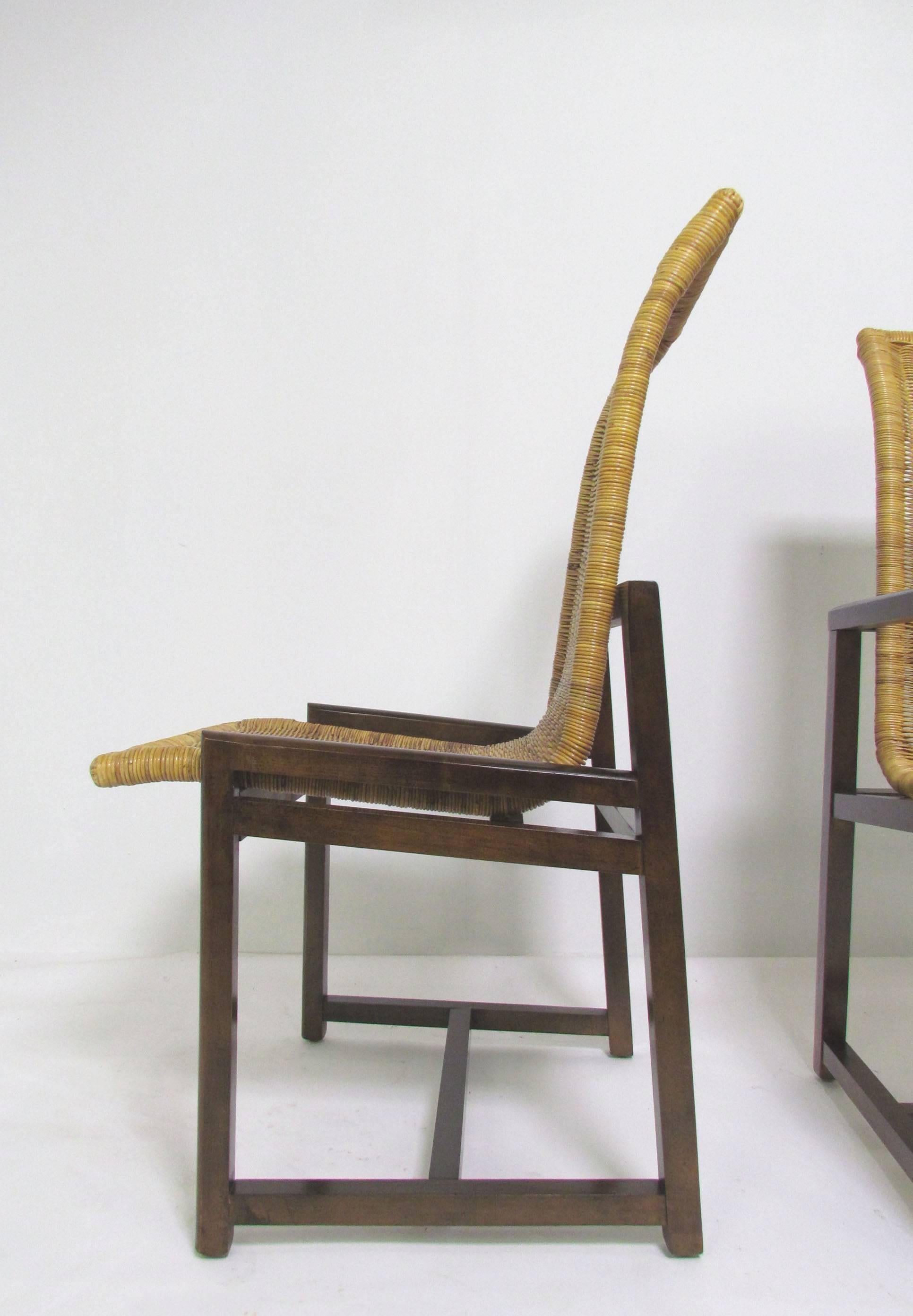Set of six dining chairs with floating rattan high back seats on dark walnut frames, circa 1970s. 

Armchairs and side chairs measure 21.75” wide, 39.5” high, and 24.5” deep. The arm height is 24 7/8”, and the seat height is 18”.
    