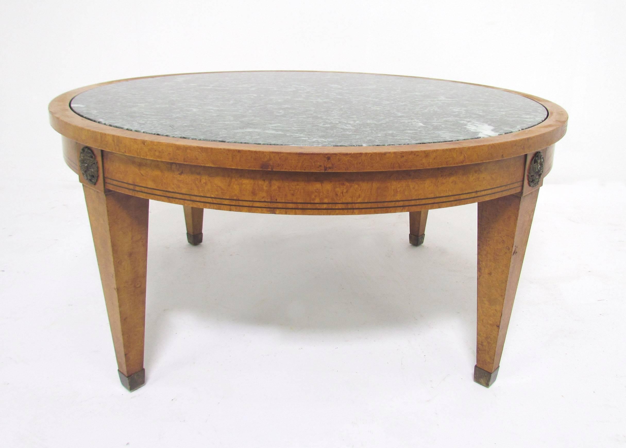 A versatile Mid-Century coffee table with marble top and brass sabots and medallion accents in the neoclassical revival style by Charak furniture, dated 1952.