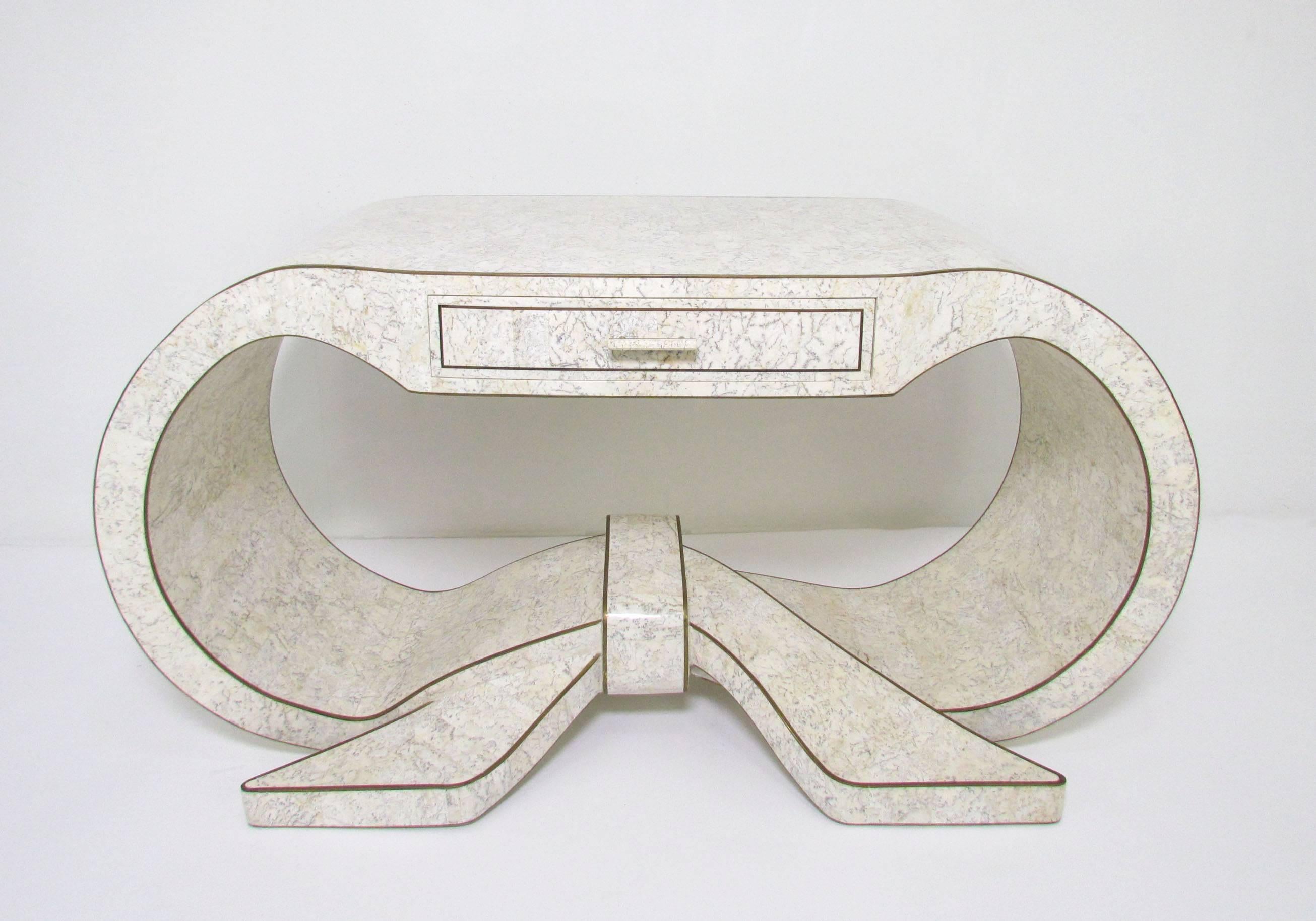 Rare ribbon form tessellated marble console table with inlaid brass trim. Could also serve as a writing desk by Maitland-Smith, circa 1970s.
