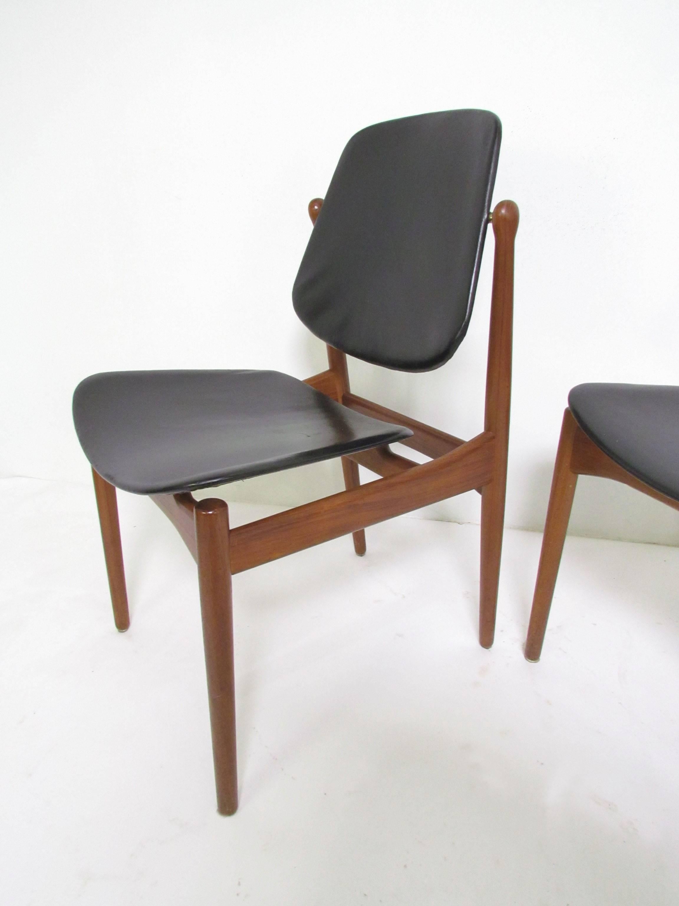 Set of six teak dining chairs with original leather upholstery designed by Arne Vodder for France & Daverkosen, Denmark, circa 1950s. One armchair and five sides, with pivoting backs and brass hardware.

Armchair measures 25" wide,