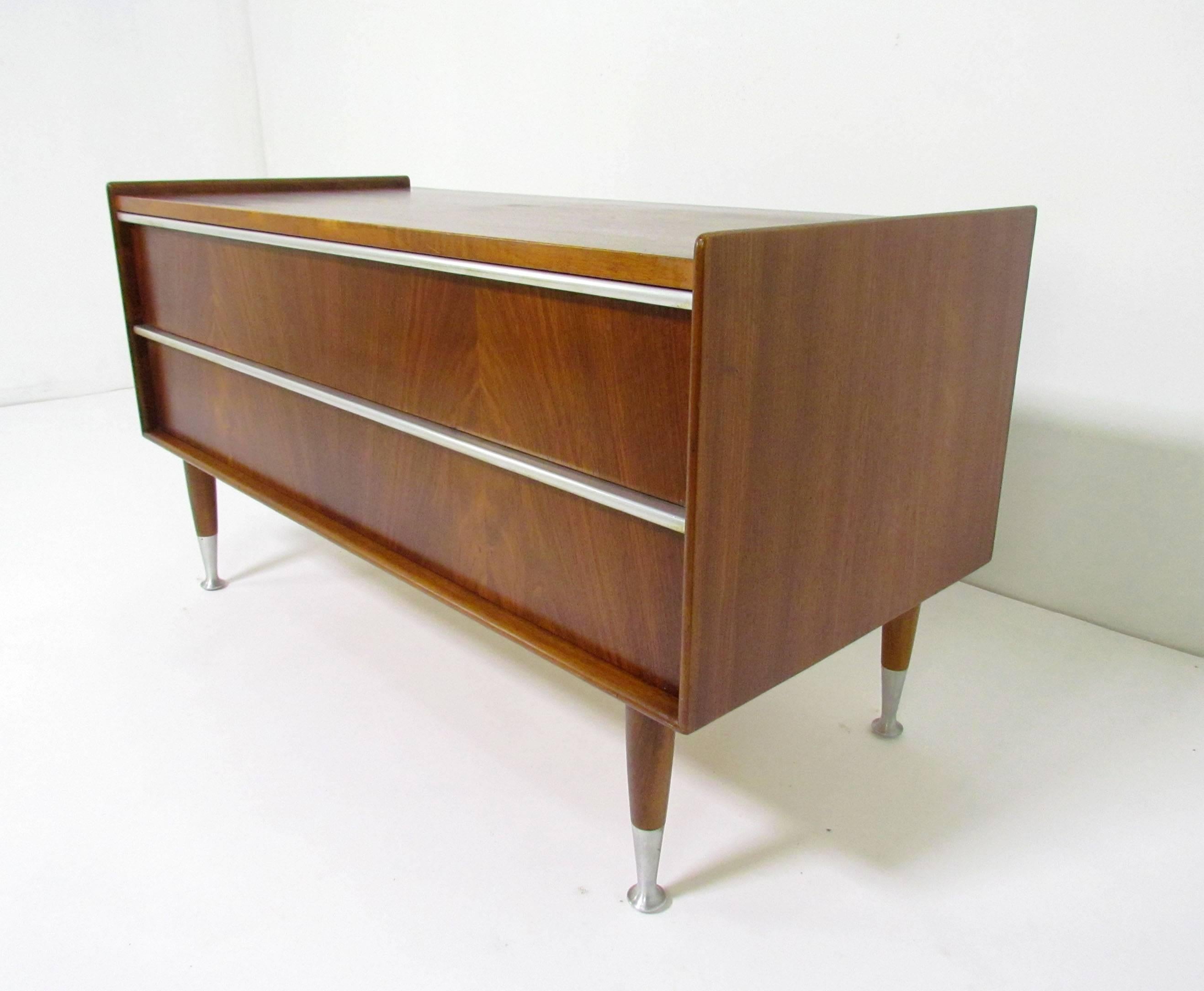 Mid-Century low blanket two-drawer chest in walnut with aluminium pulls and spun aluminium feet, designed by Edmond Spence, made in Sweden, in the early Danish modern style. Stabile enough to also serve as an end of bed bench while one puts on