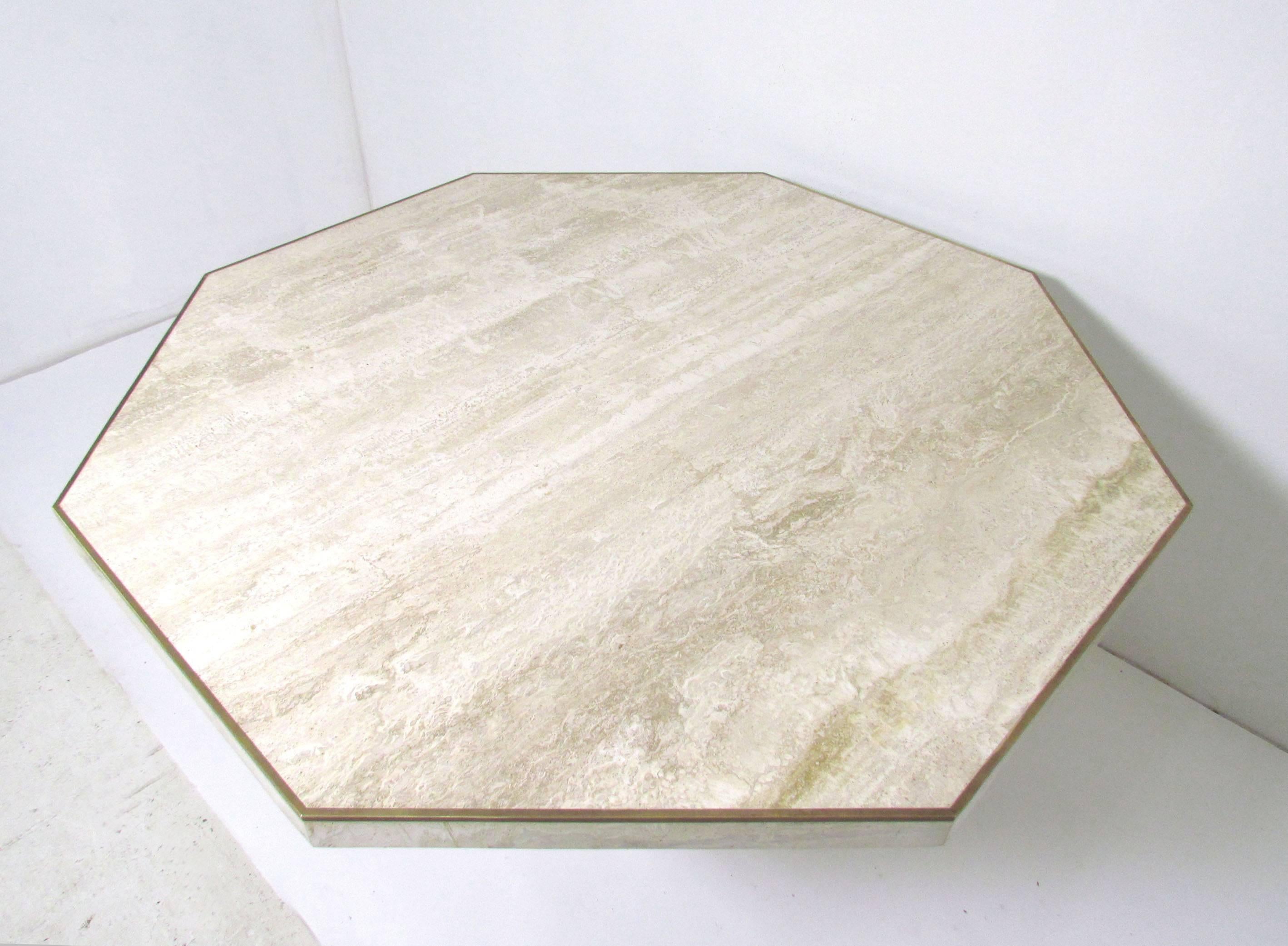 Dining table in travertine with inlaid brass trim, made in Italy by Stone International for Roche Bobois, circa 1980s. Octagonal form can seat eight people. This identical table was also created for and sold by Ello Furniture.

Measures 51.5